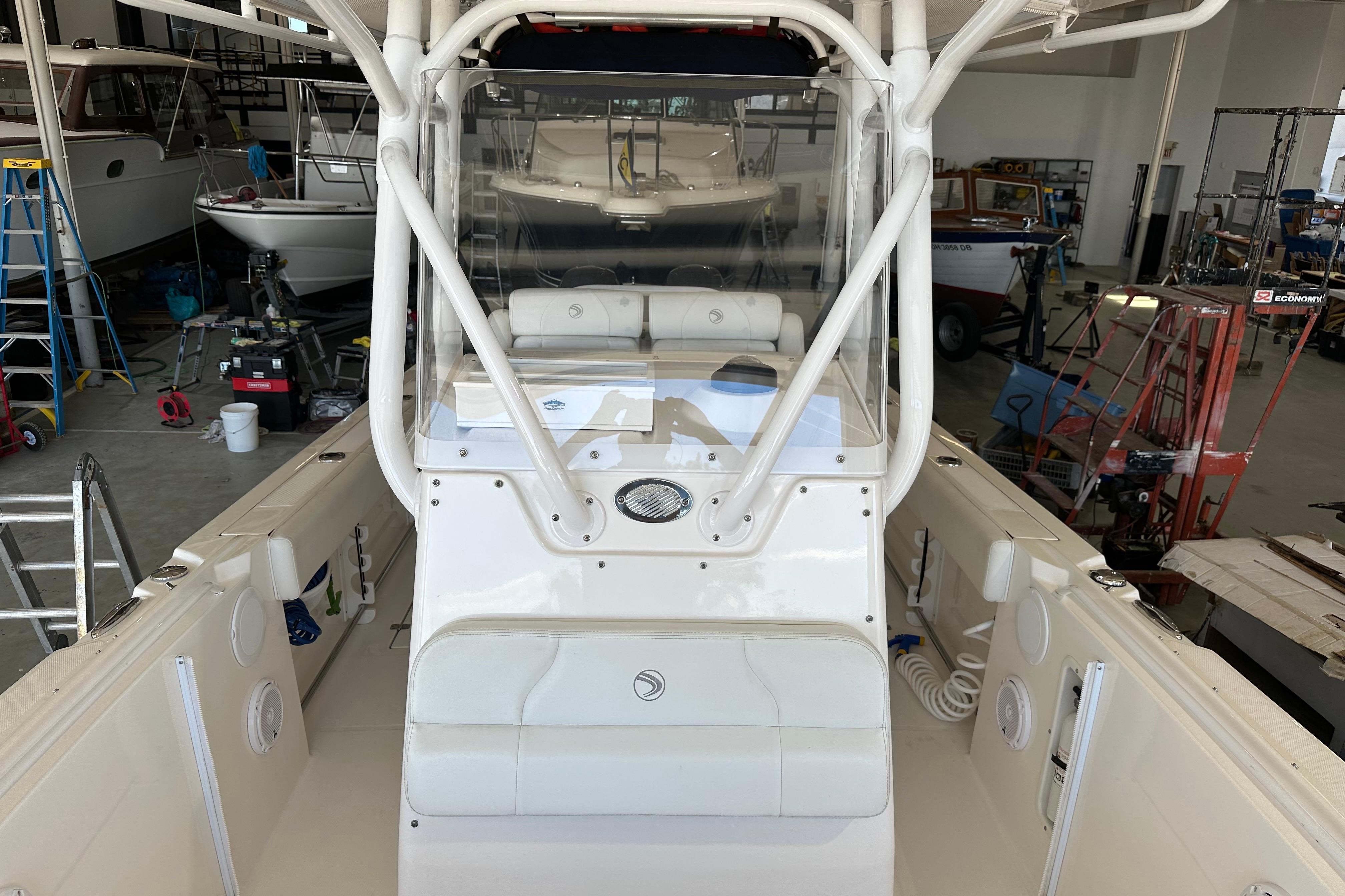 2015 Edgewater 245CC boat interior in a workshop setting, showcasing helm and seating area.