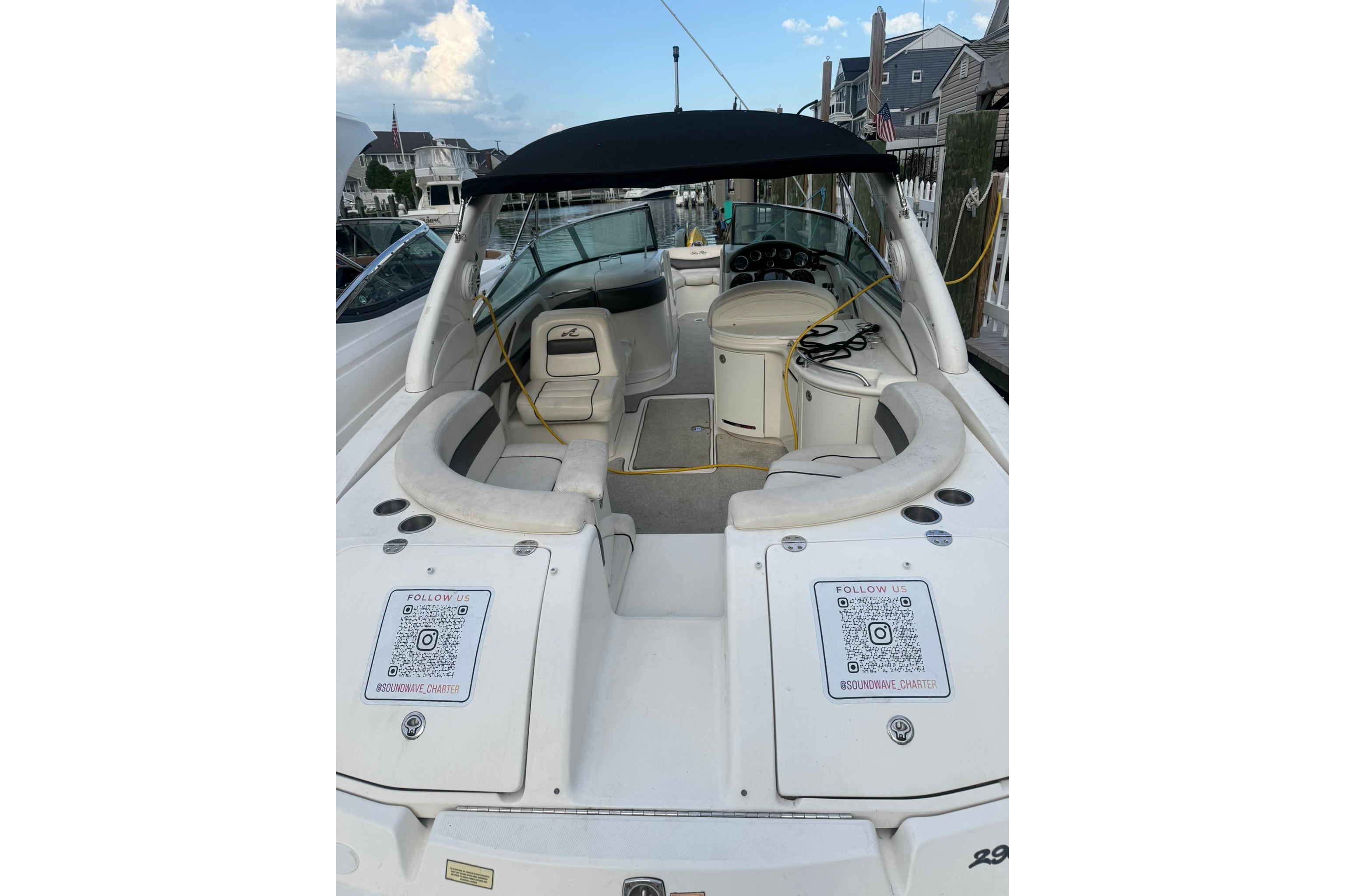 2005 Sea Ray 290 SLX boat with spacious seating, docked at a marina under a clear sky.