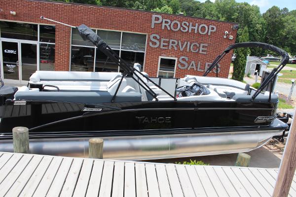 2025 Tahoe Pontoon Cascade Quad Lounger at dealership, black exterior, docked near service center.