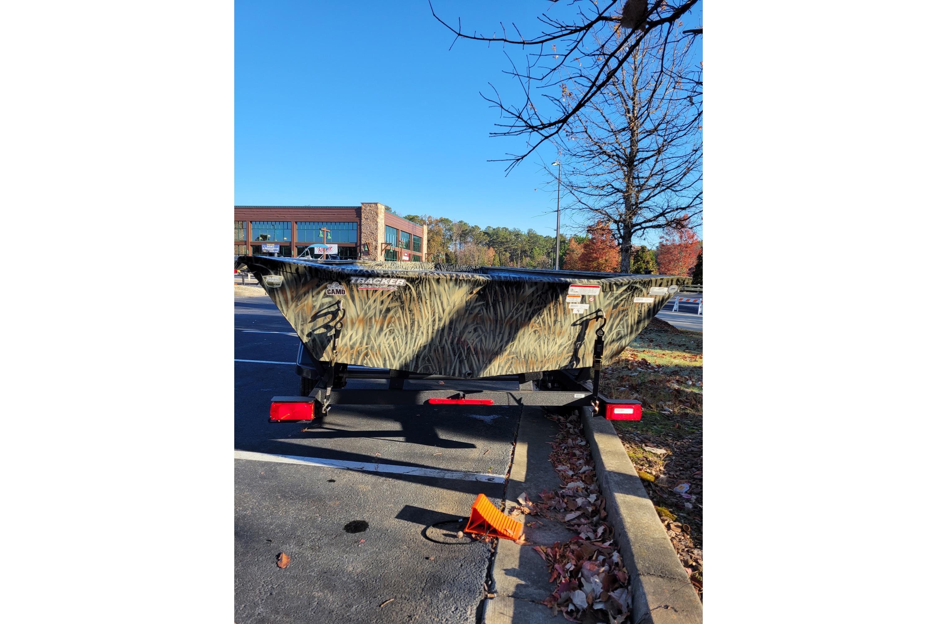 2025 Tracker Grizzly 1860 Utility boat with camo design parked outdoors.
