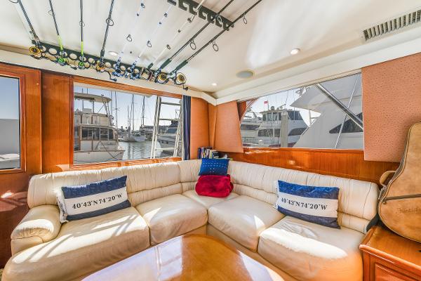 Luxurious interior of 1999 Viking 47 Convertible yacht with plush seating and fishing rods.