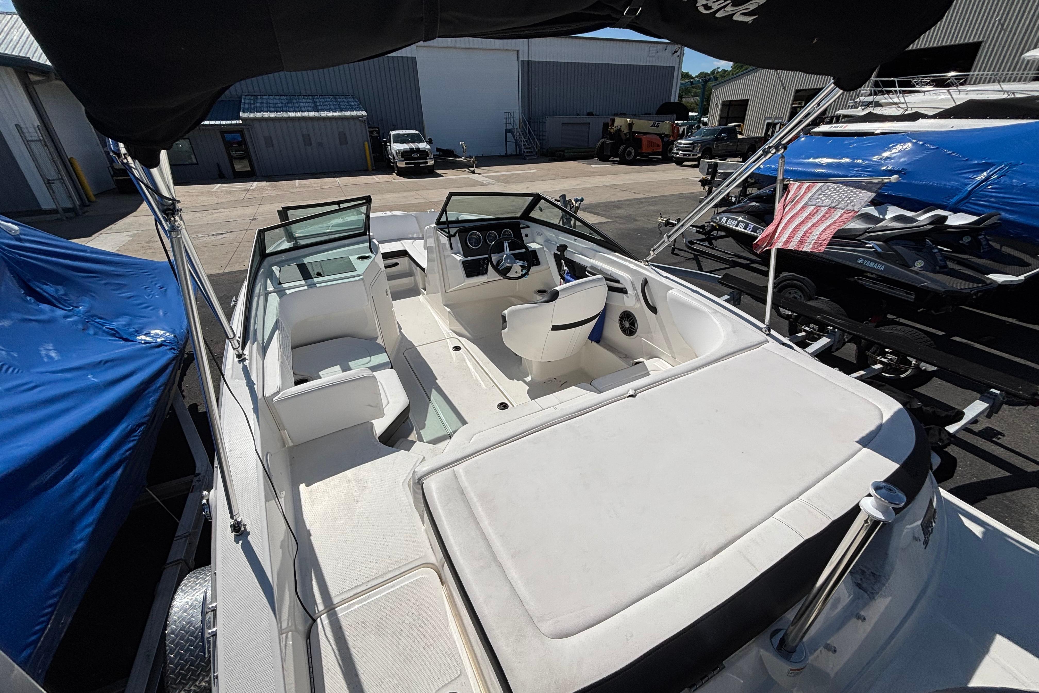 2022 Sea Ray SPX 190 Outboard boat interior with seating and steering wheel, docked outdoors.