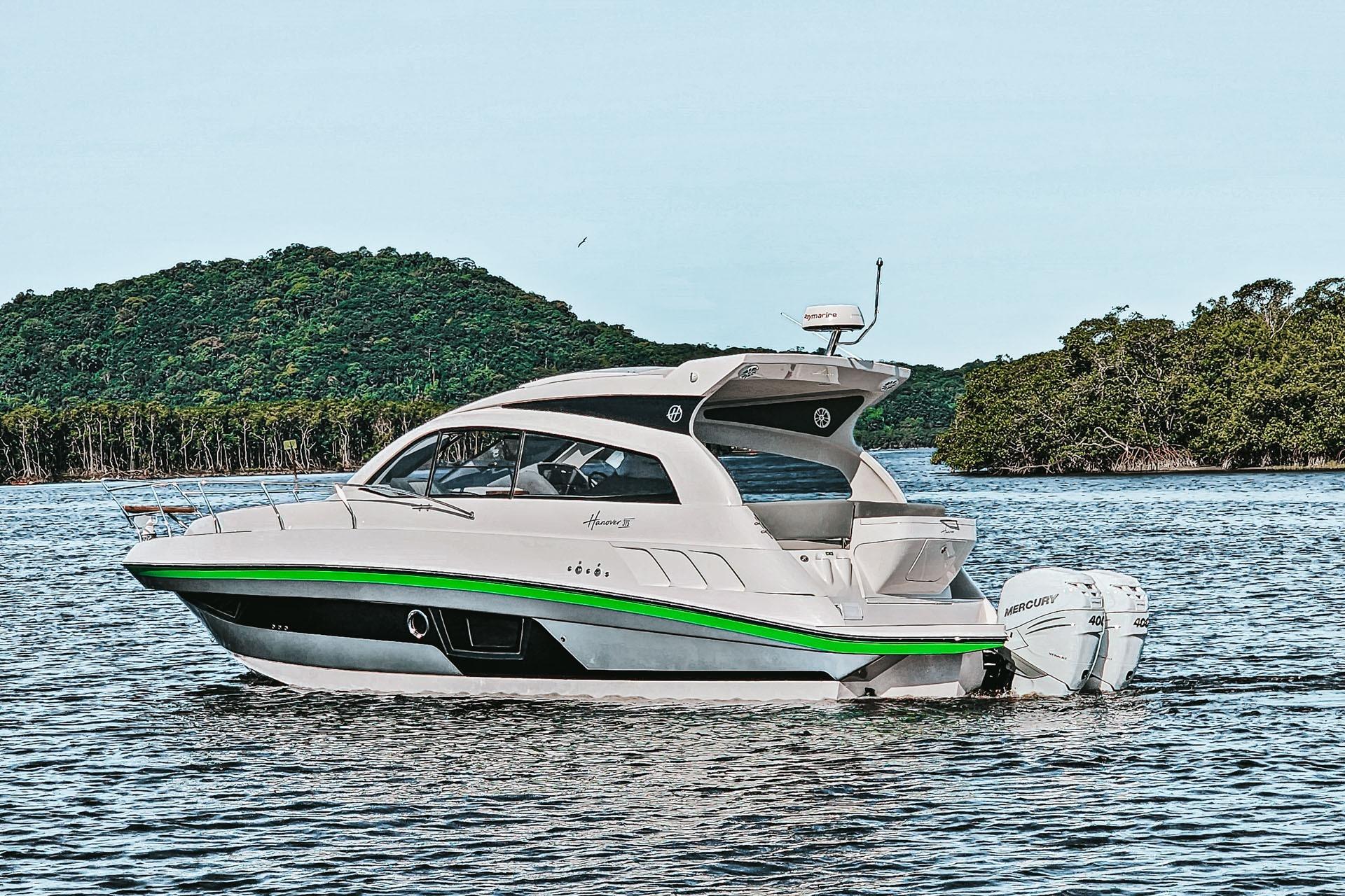 2026 Hanover 375 boat on water with lush green island backdrop.