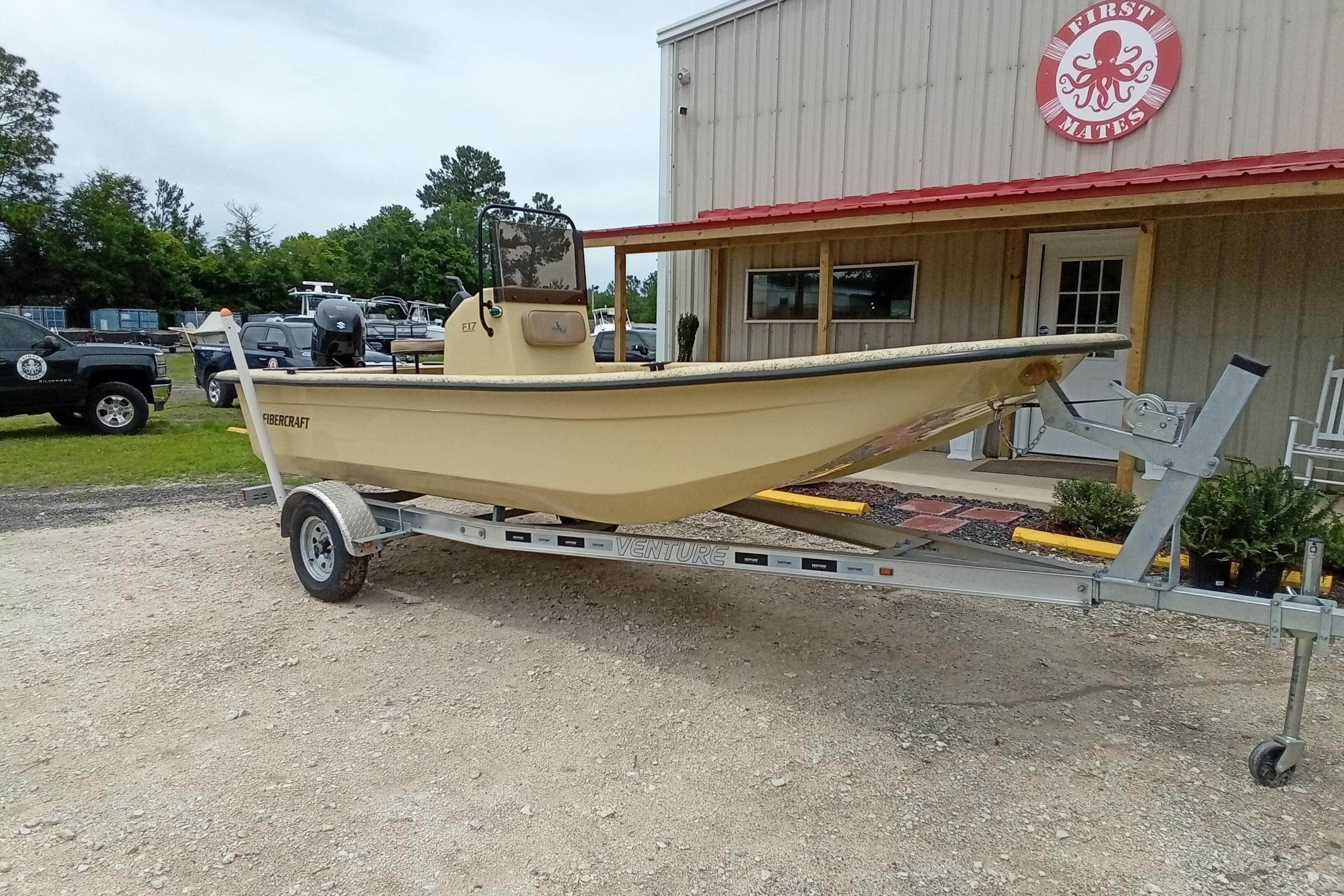 2025 Fibercraft F17 boat on trailer outside a building with red roof.