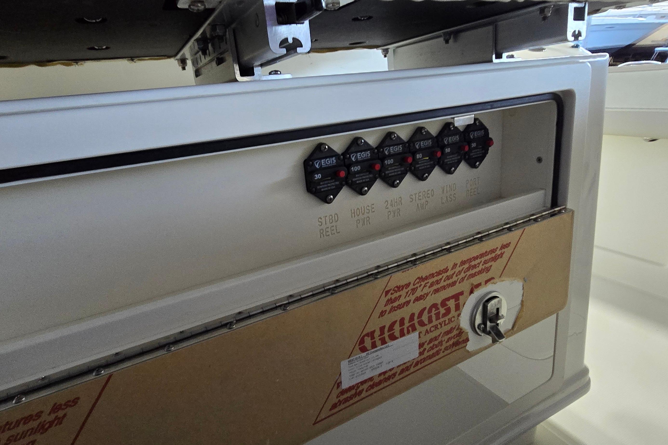 Control panel of 2024 WorldCat 280 CC-X boat with labeled switches and protective cover.