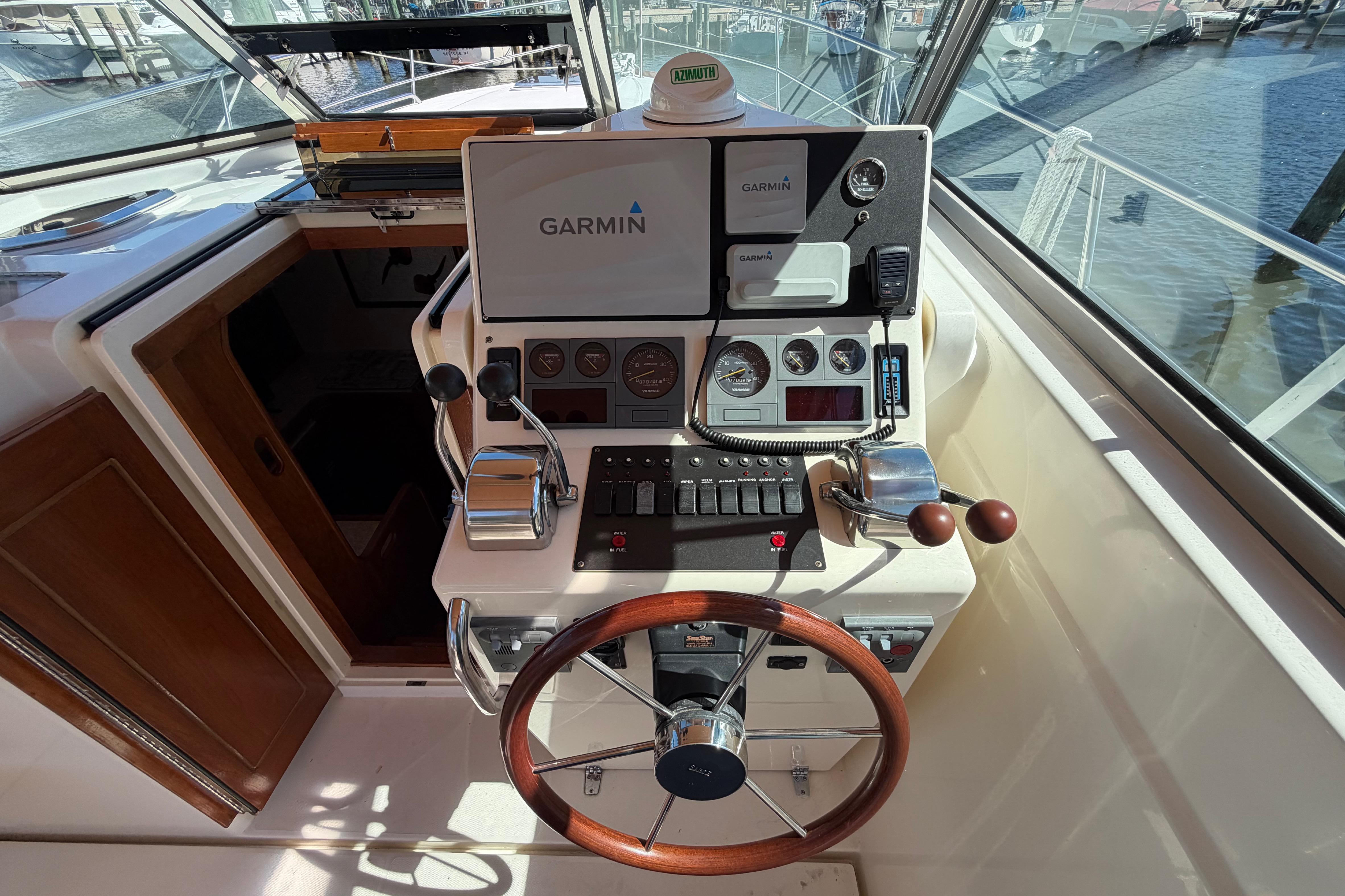 Helm of 2000 Sabreline 36 Express with Garmin navigation system and wooden steering wheel.