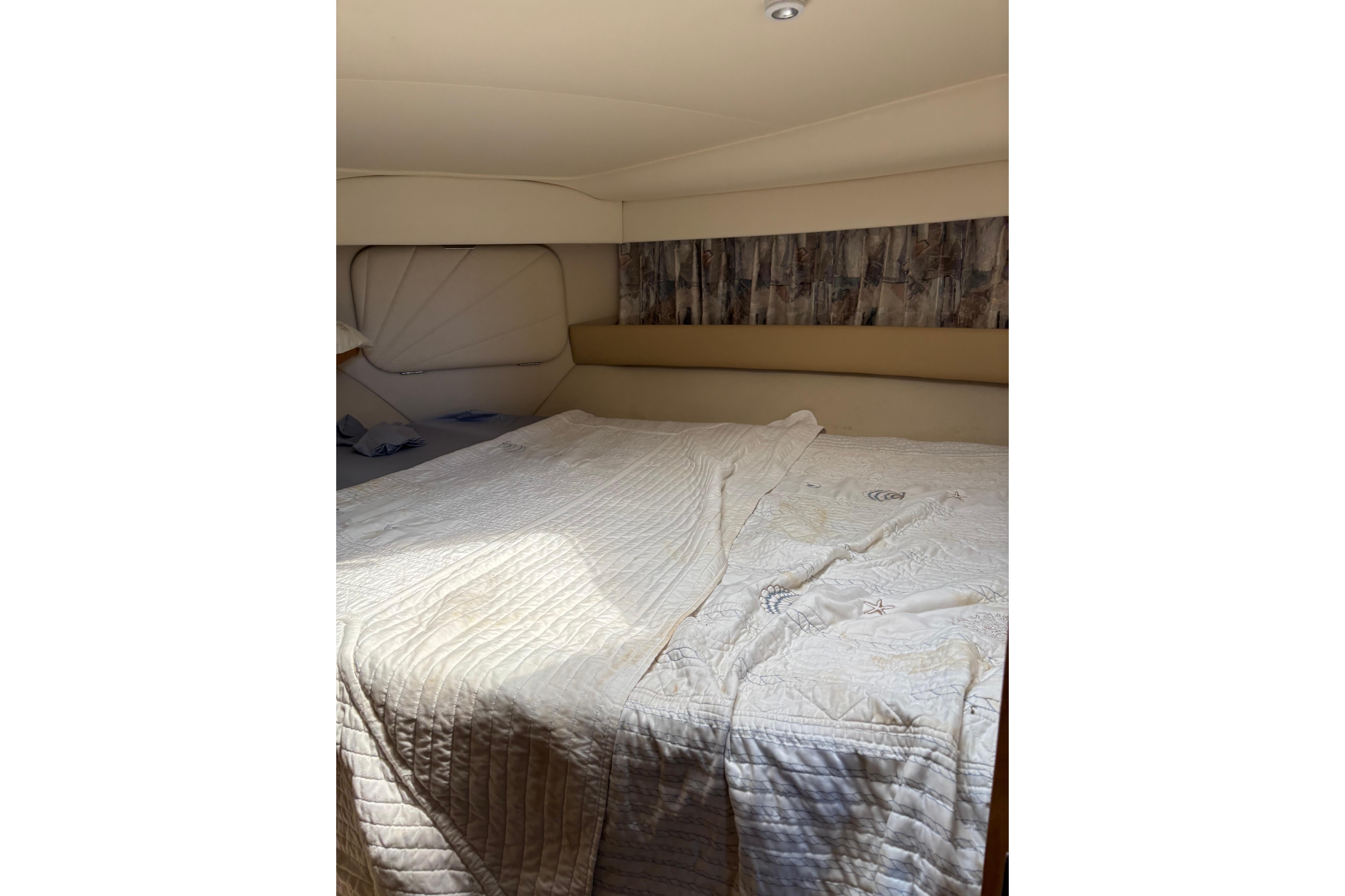 Interior cabin of 1997 Carver 400 Cockpit Motor Yacht with cozy bedding.
