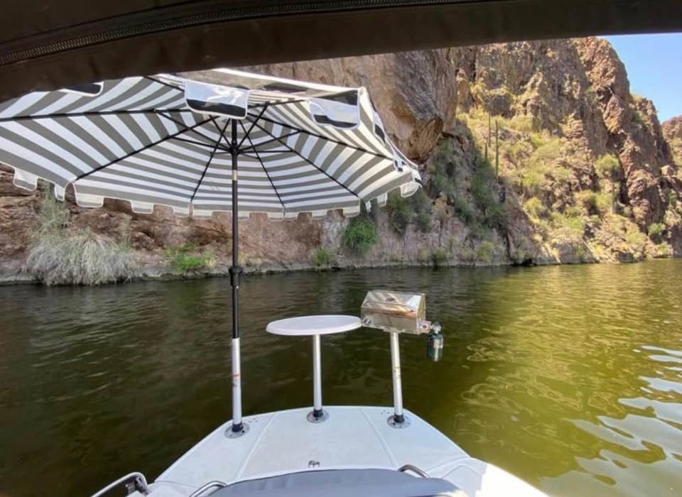 Cruisers Sport Series 29SS boat with umbrella on calm water.