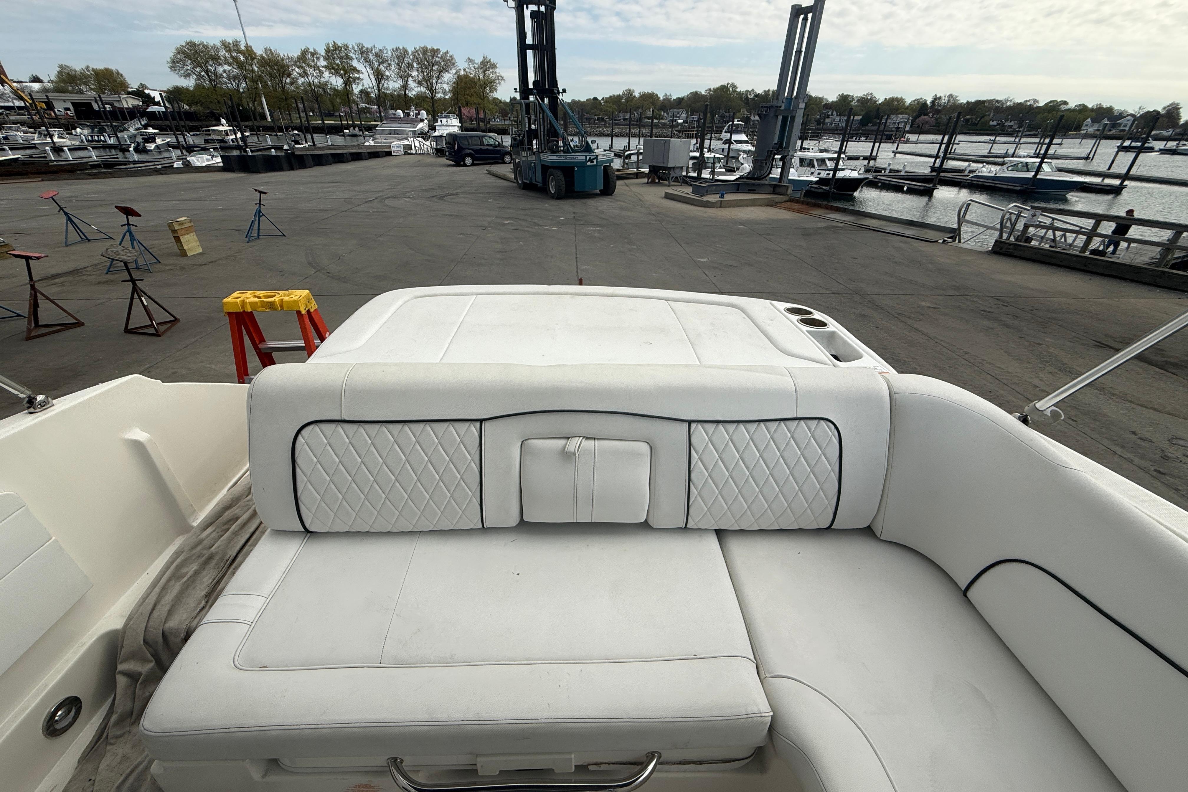 2015 Sea Ray 240 Sundeck boat interior with white cushioned seating at marina.