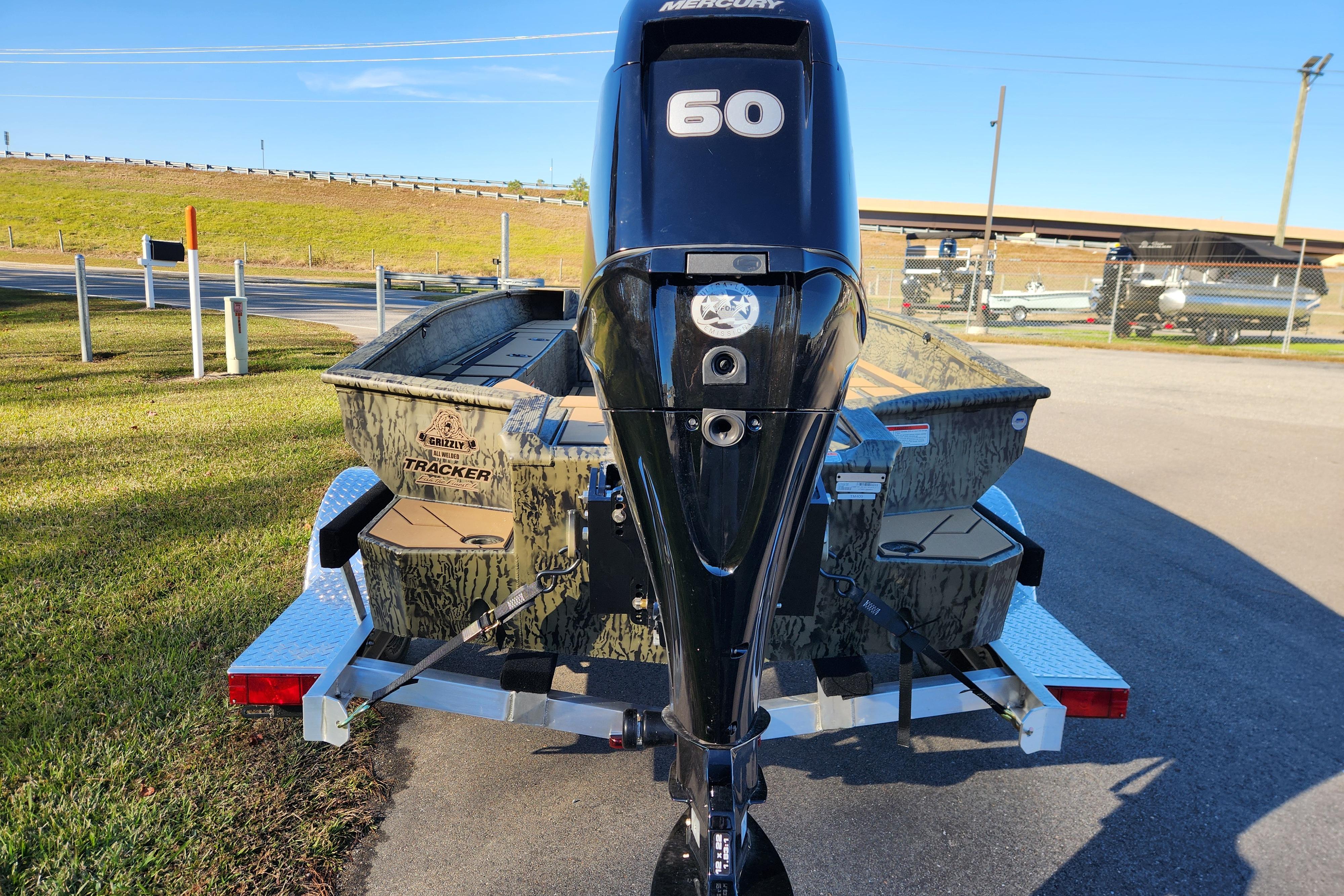 2026 Tracker Grizzly 1756 T Marsh boat with Mercury 60 engine, parked outdoors.