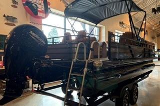 2026 Ranger 220FC pontoon boat displayed indoors with canopy and outboard motor.