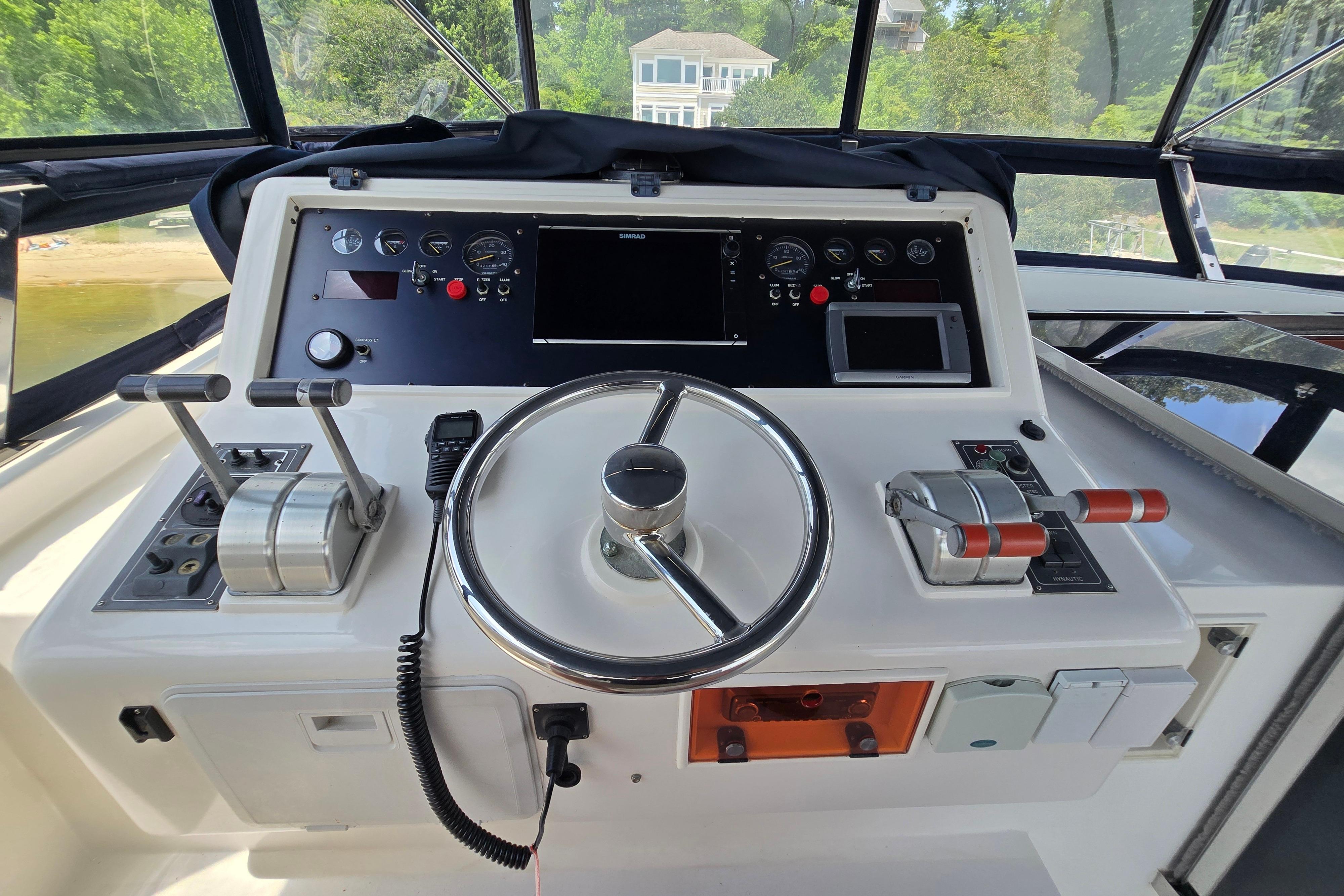 Helm of 2004 Grand Harbour 58 yacht with steering wheel and control panel.