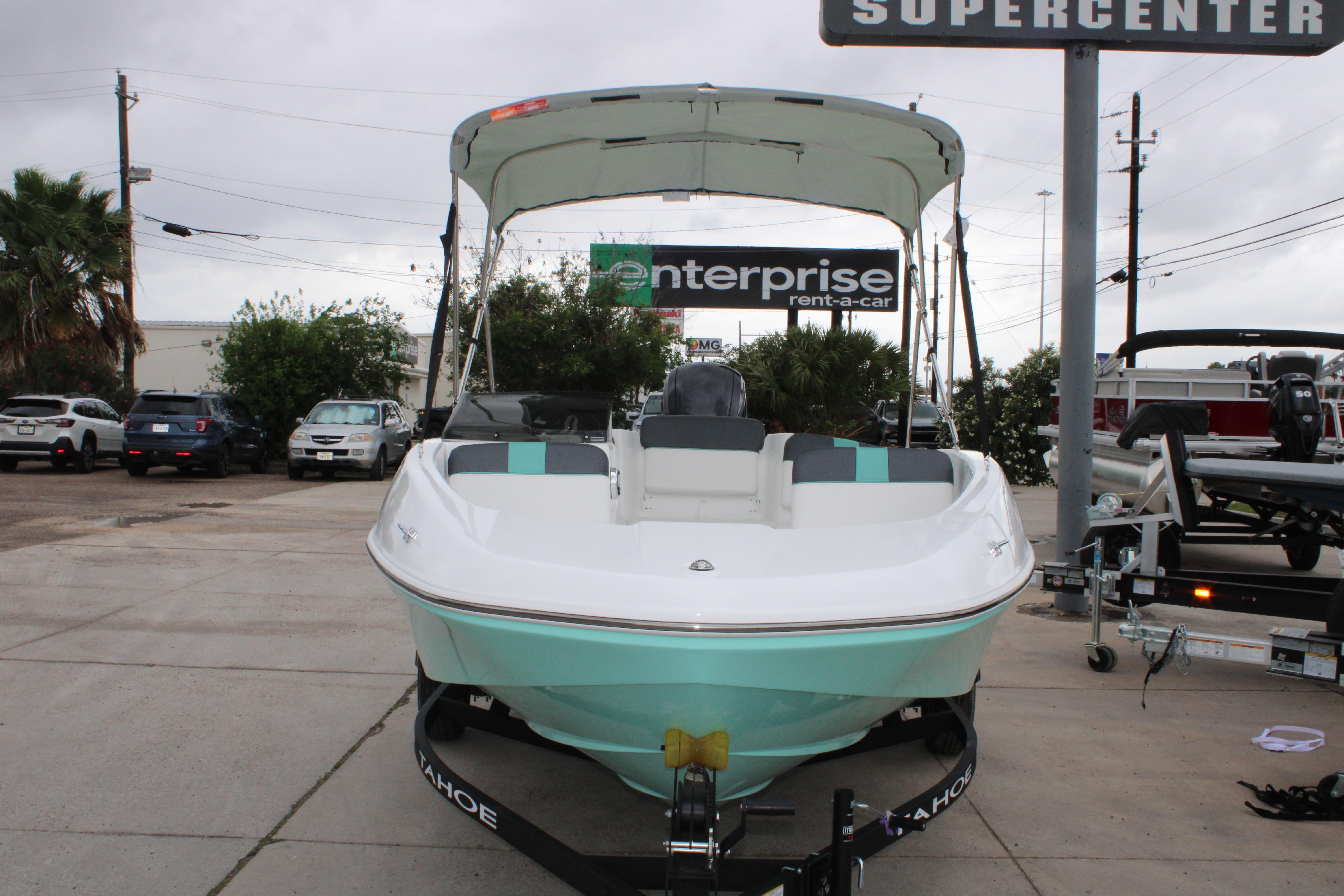 2026 Tahoe T16 boat displayed at a dealership with canopy and trailer.