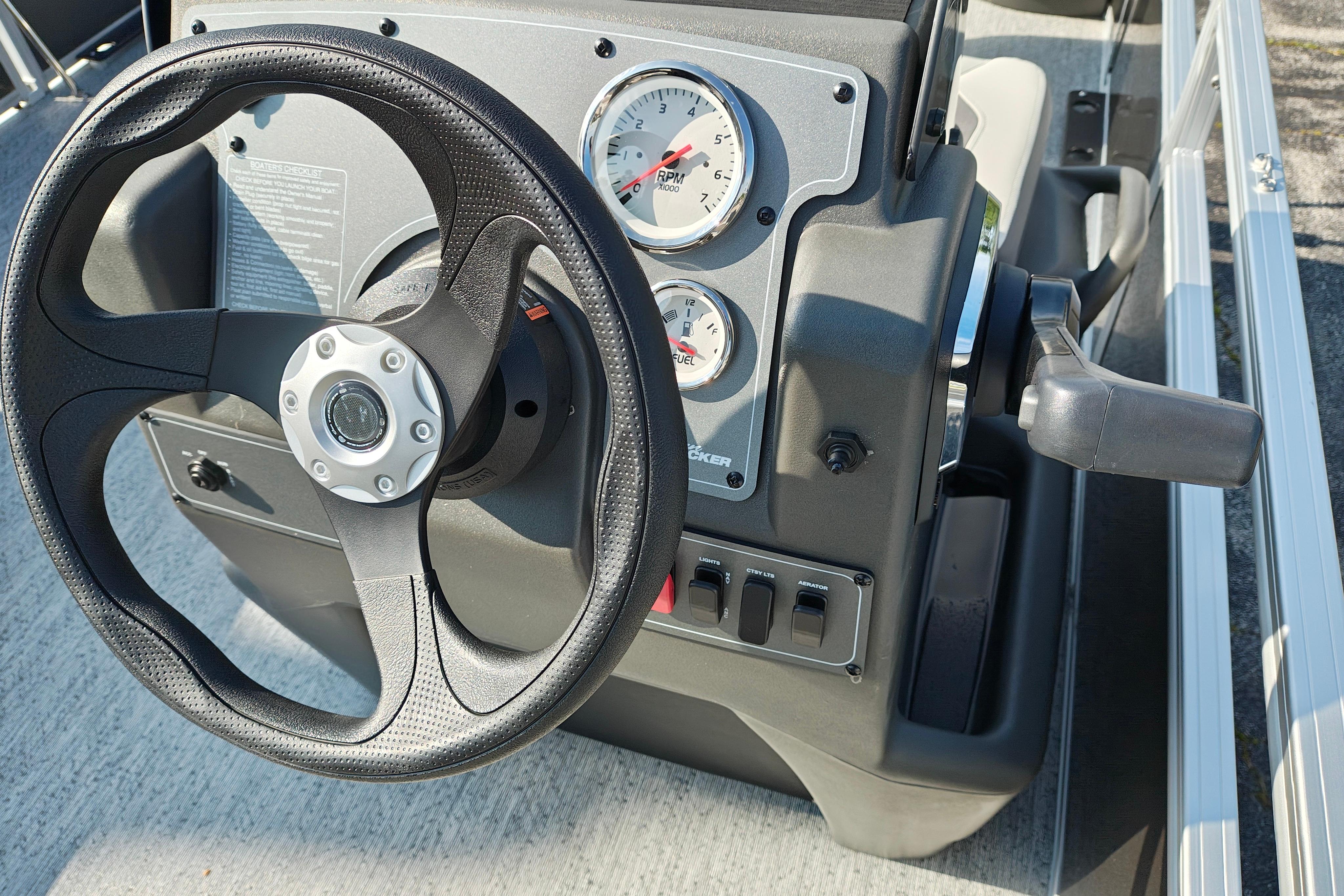 Steering console of 2026 Sun Tracker Bass Buggy 18 DLX with gauges and controls.