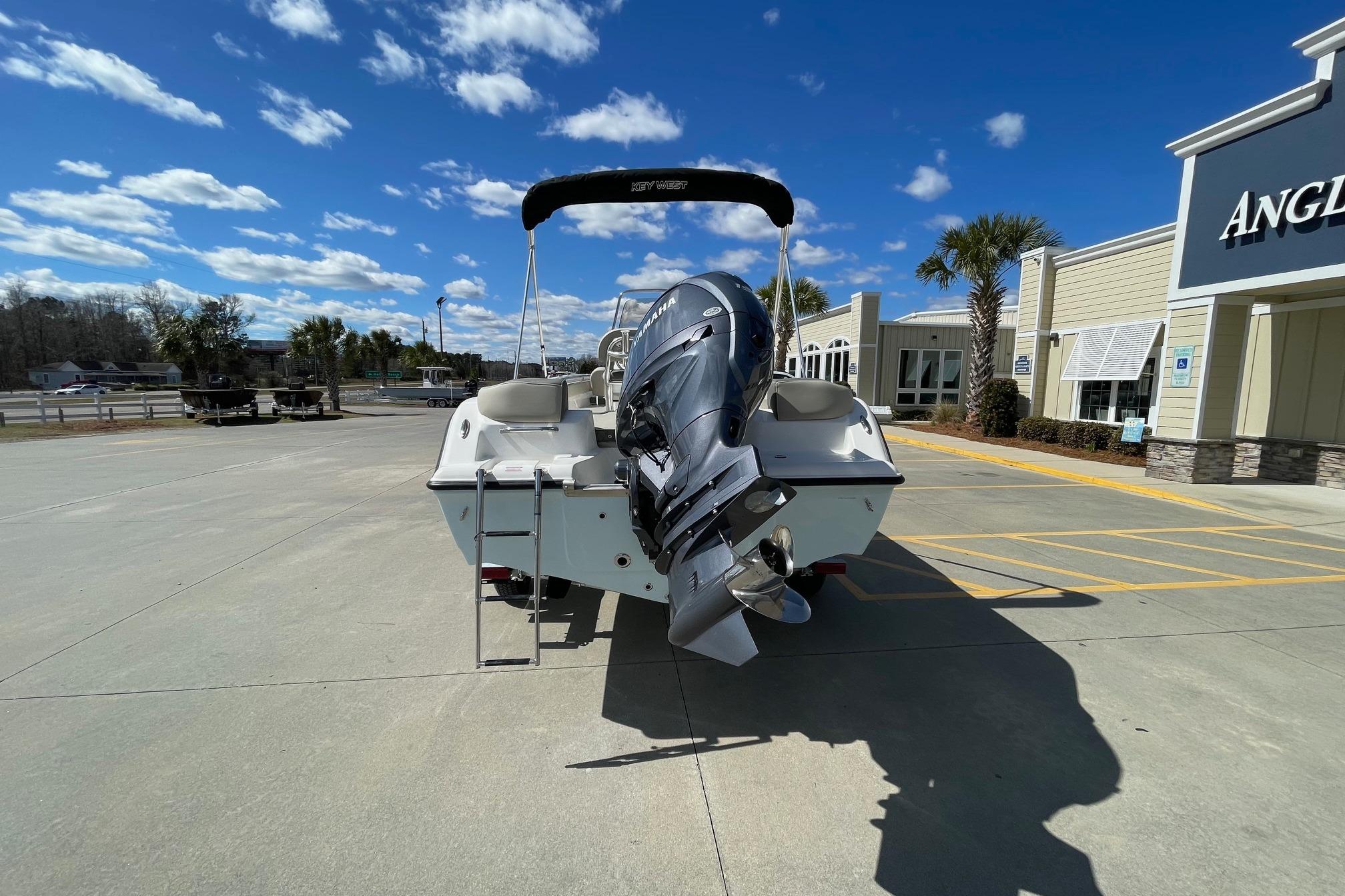 2026 Key West 203 FS boat with outboard motor in a sunny dealership lot.
