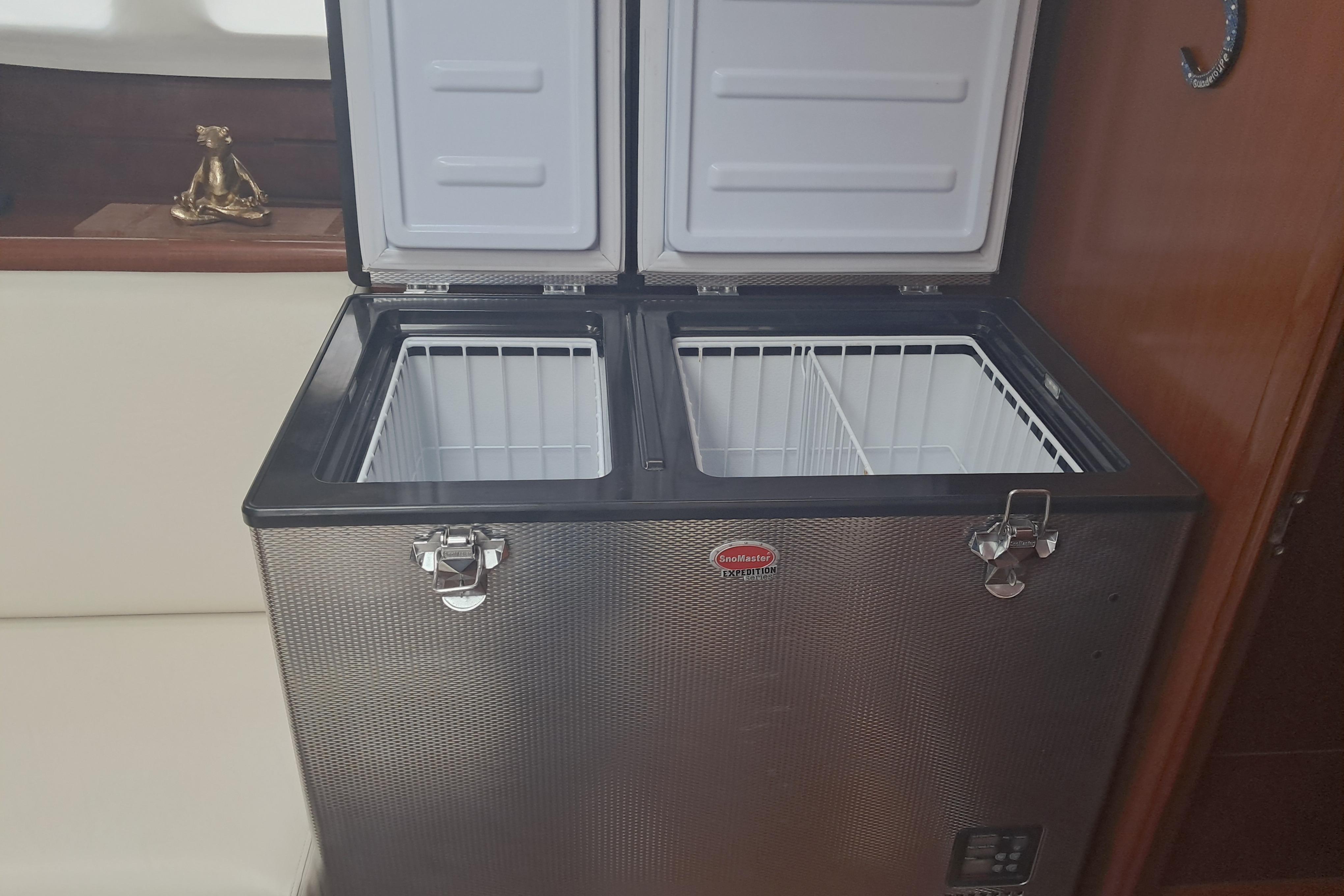 Dual-compartment fridge in 2006 Beneteau 423 yacht interior, featuring open lids and wire baskets.