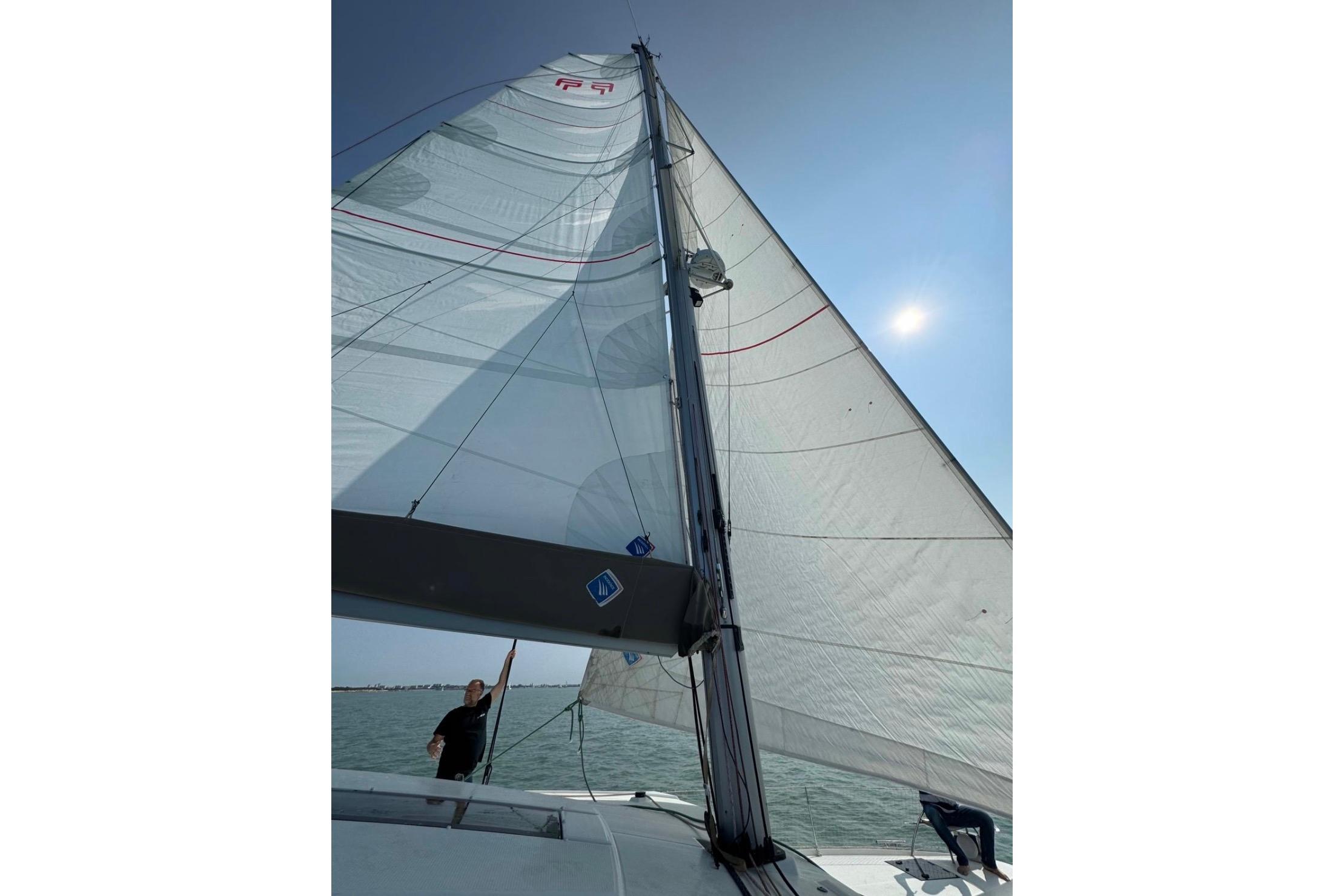 2019 Fountaine Pajot Astrea 42 Catamaran sailing under clear blue sky.