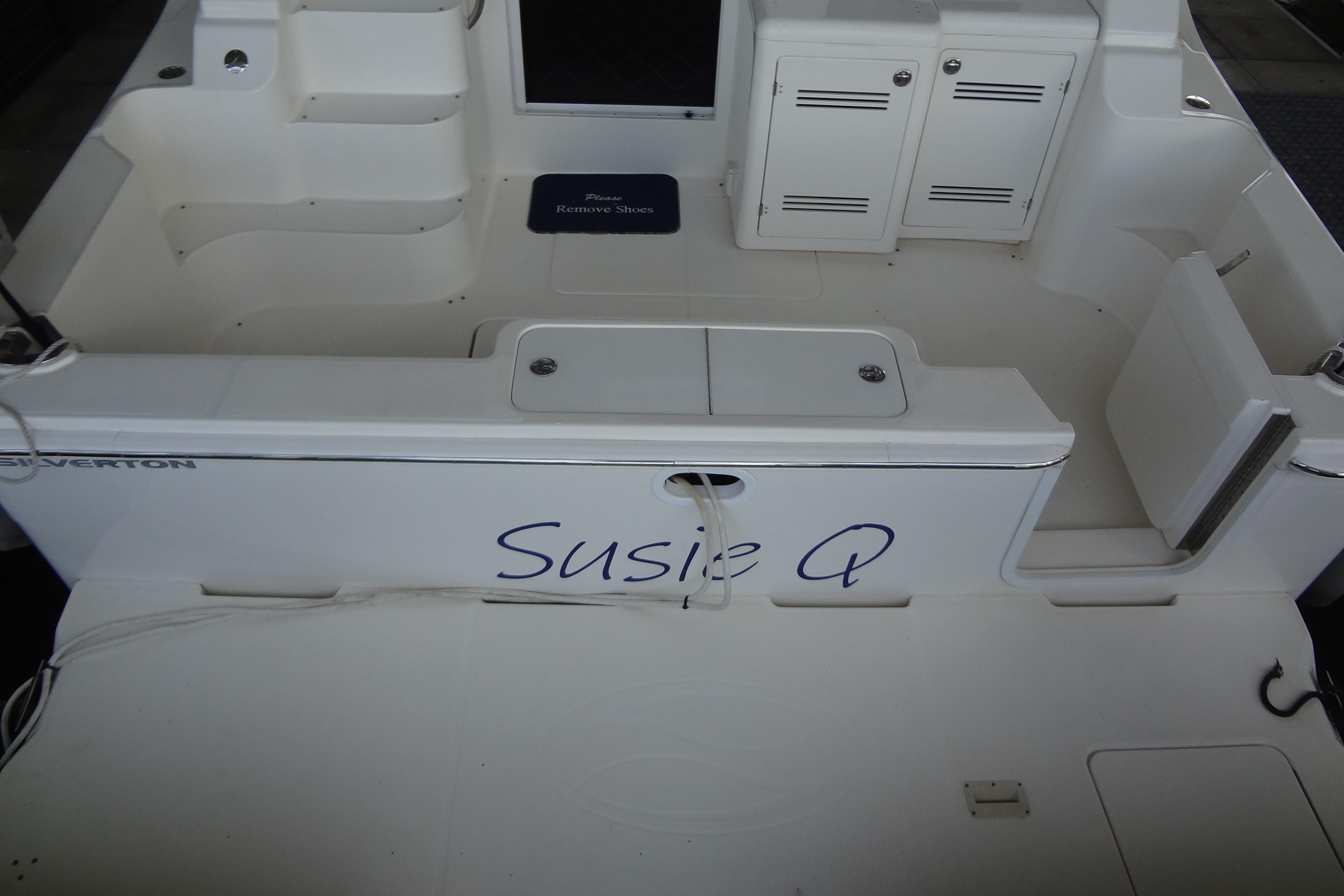2005 Silverton 34 Convertible boat deck with "Susie Q" name, white seating, and storage compartments.
