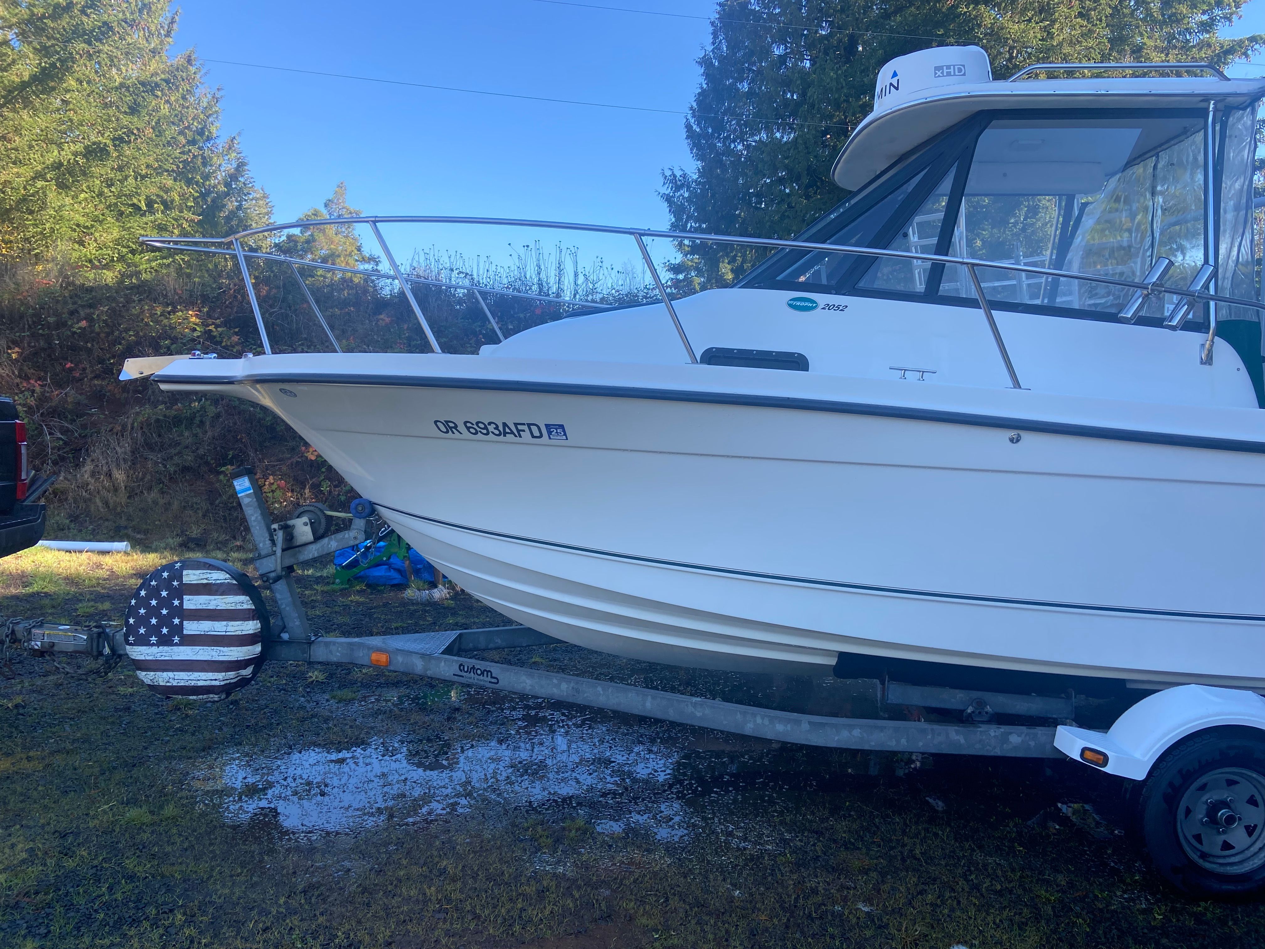 A 2003 Bayliner Trophy Pro 2052 WA boat on a trailer outdoors.