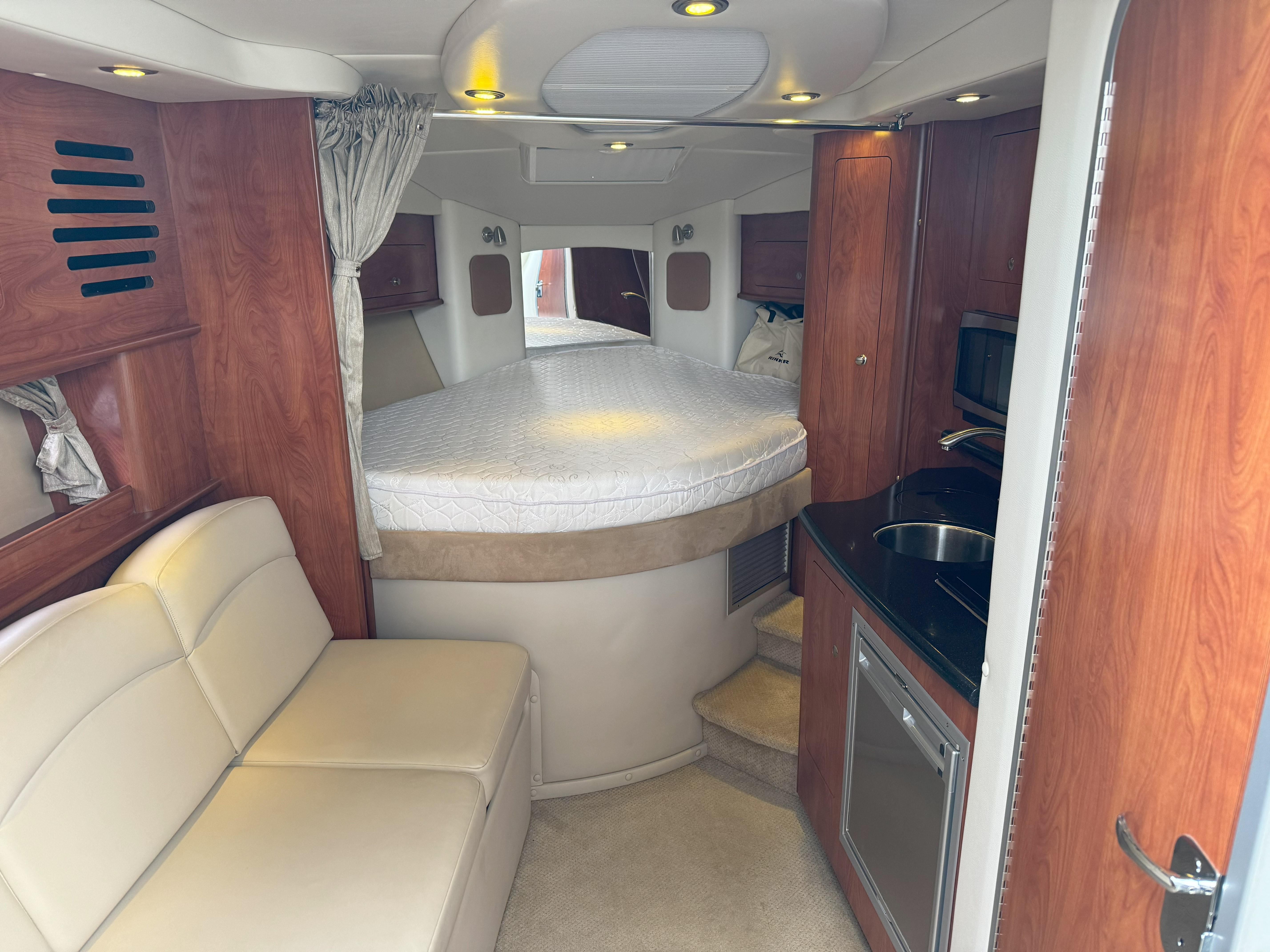 Interior of 2010 Rinker 310 Express Cruiser with bed and kitchenette.