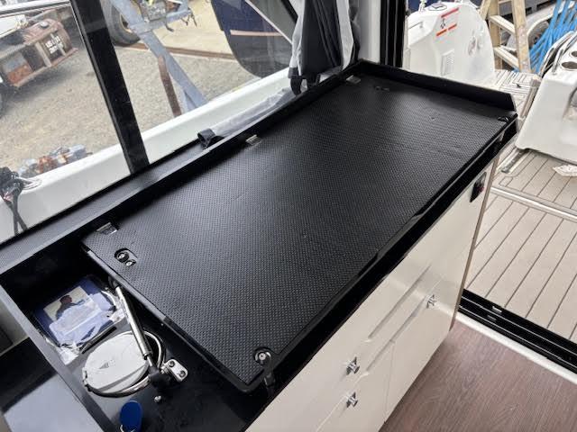 Interior view of 2019 Beneteau Antares 27 boat with black countertop and storage cabinets.