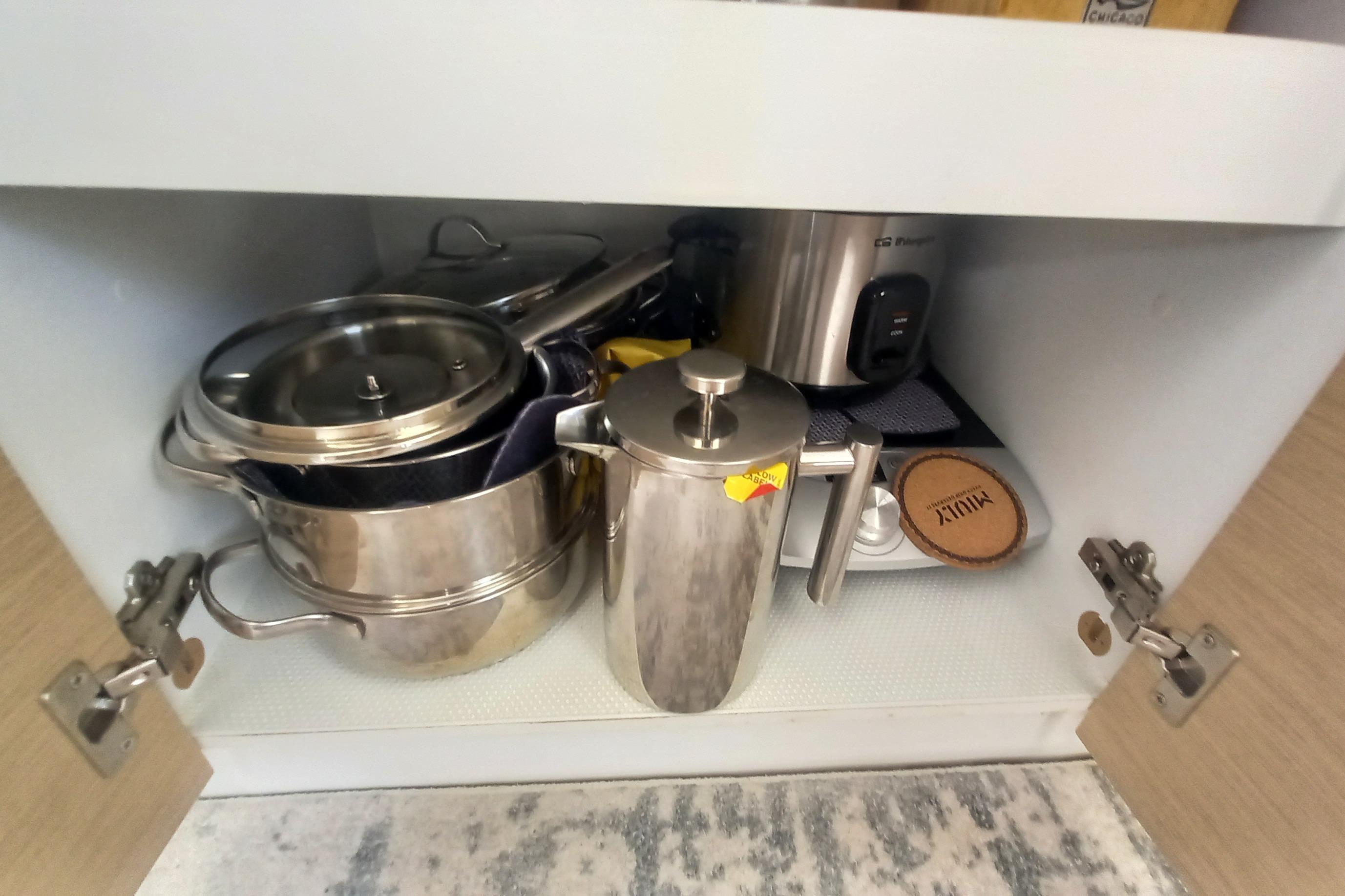 Kitchen cabinet with stainless steel cookware and appliances on a 2018 Fountaine Pajot Lucia 40.