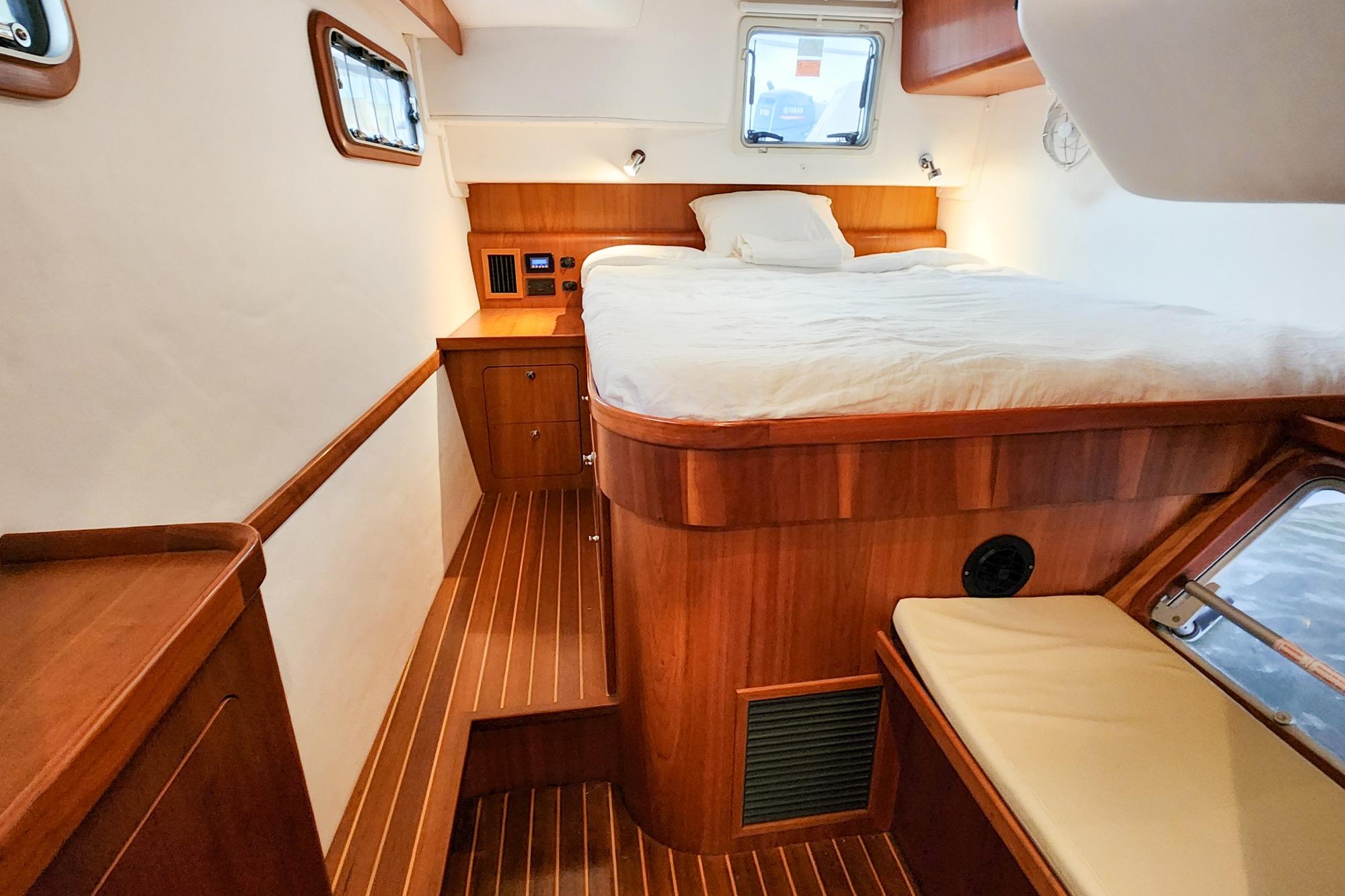 Luxurious cabin interior of 2019 Antares 44GT yacht with wooden finish and cozy bed.
