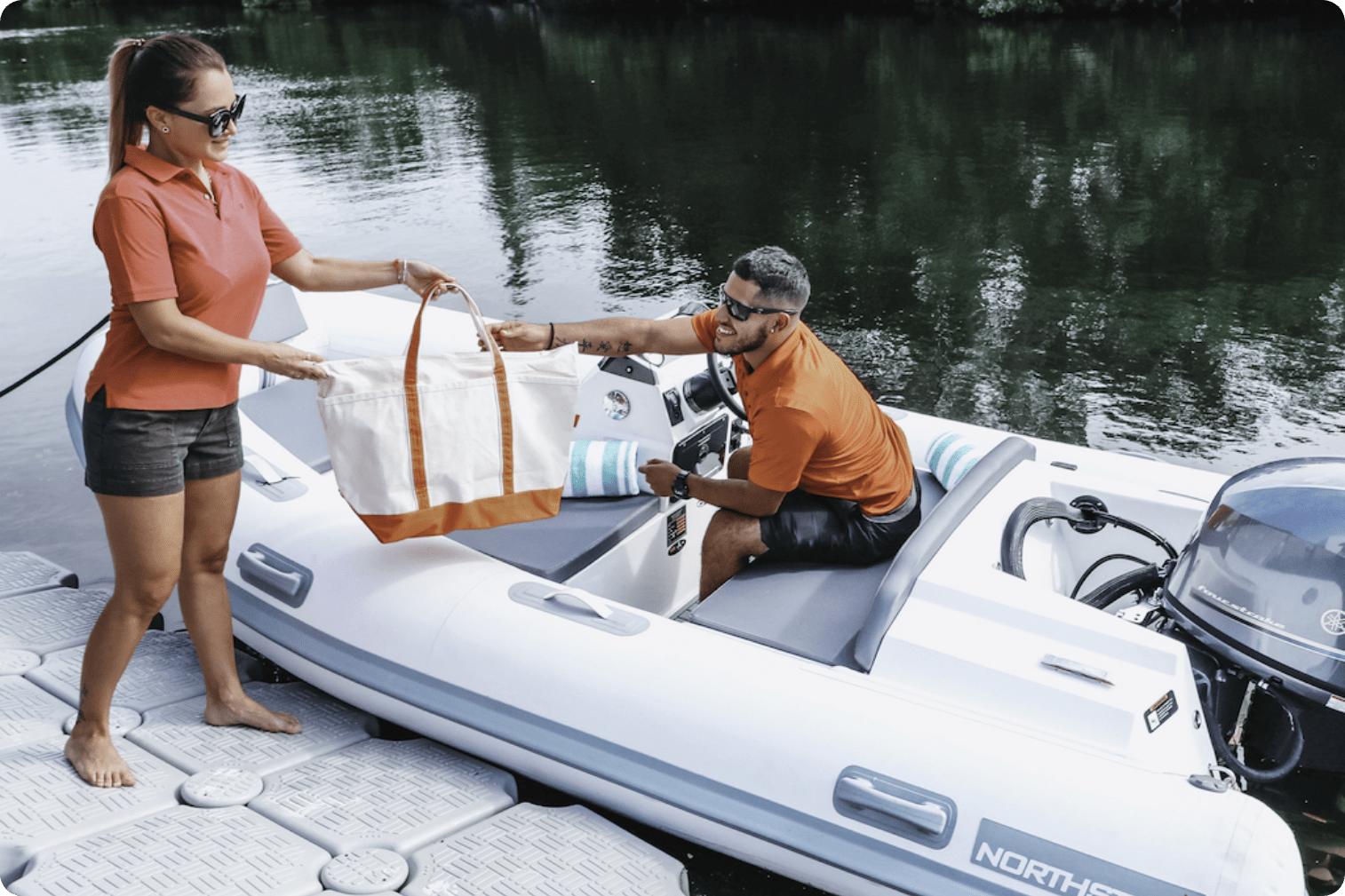Couple loading bag onto 2022 Northstar Axis 3.1 boat at dock.