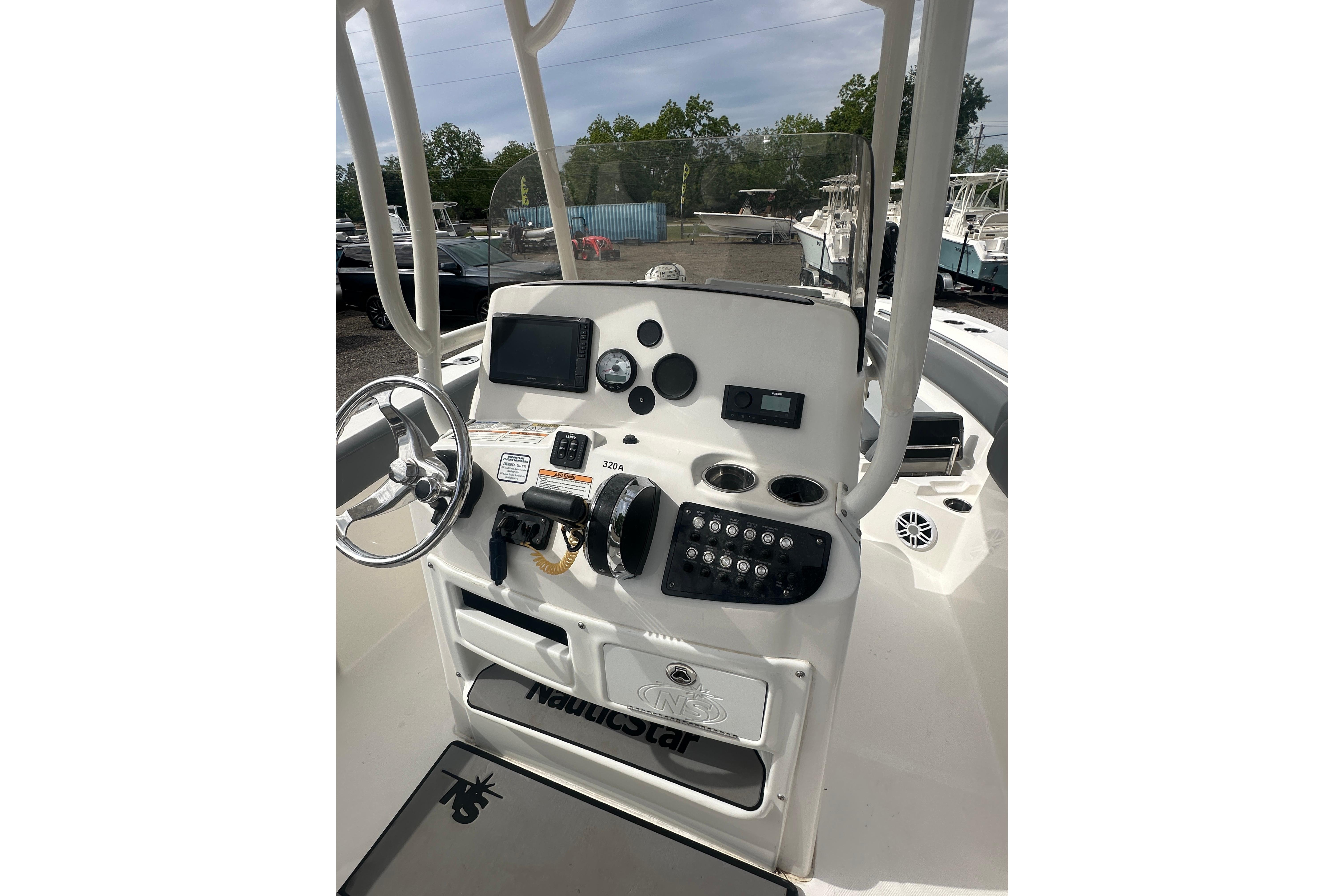 2023 NAUTIC STAR 22 L boat dashboard with steering wheel and control panel.