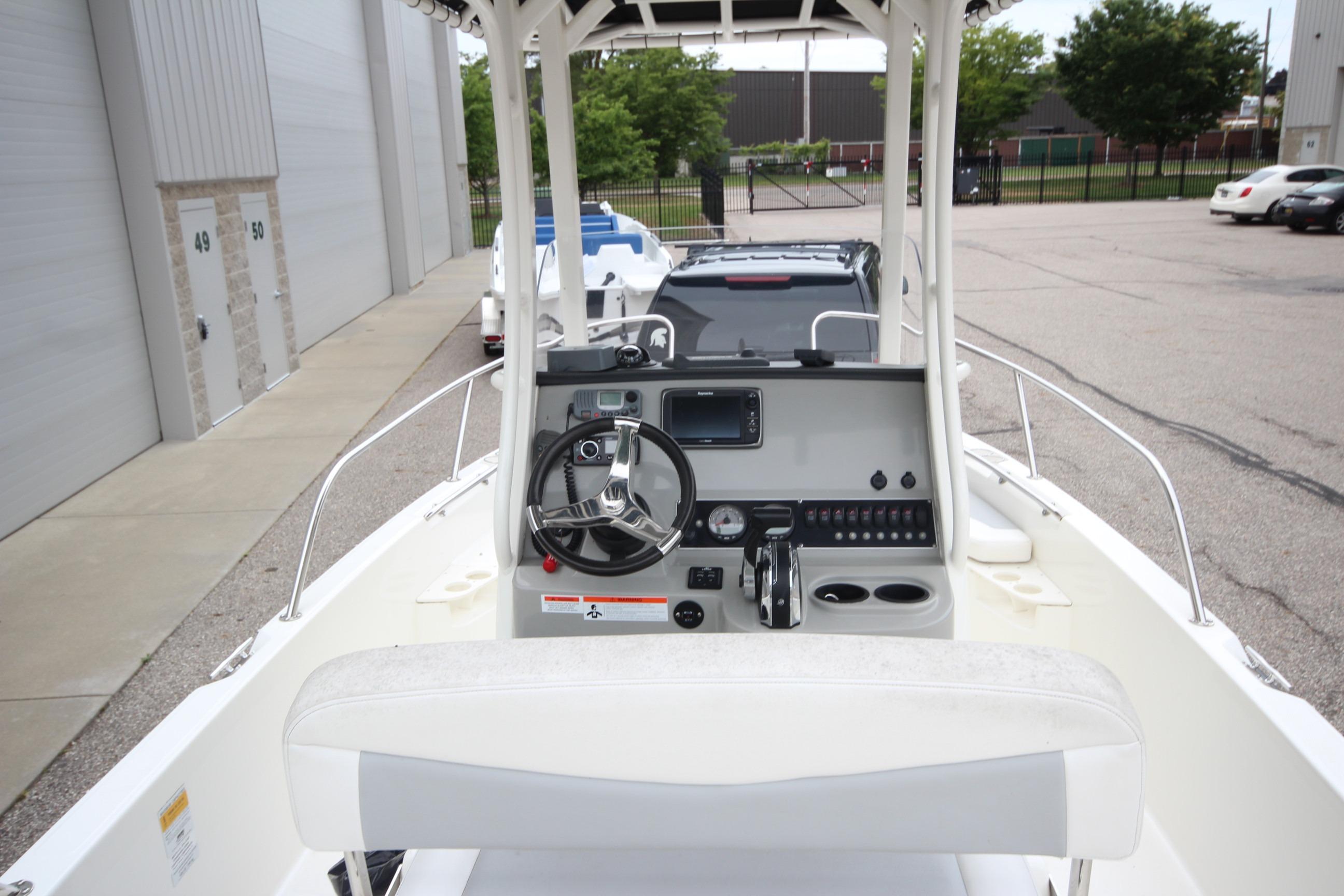 2014 Boston Whaler 210 Dauntless boat interior with steering console and seating.