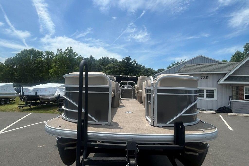 2023 Sun Tracker Party Barge 22 DLX pontoon boat parked outdoors under a clear sky.