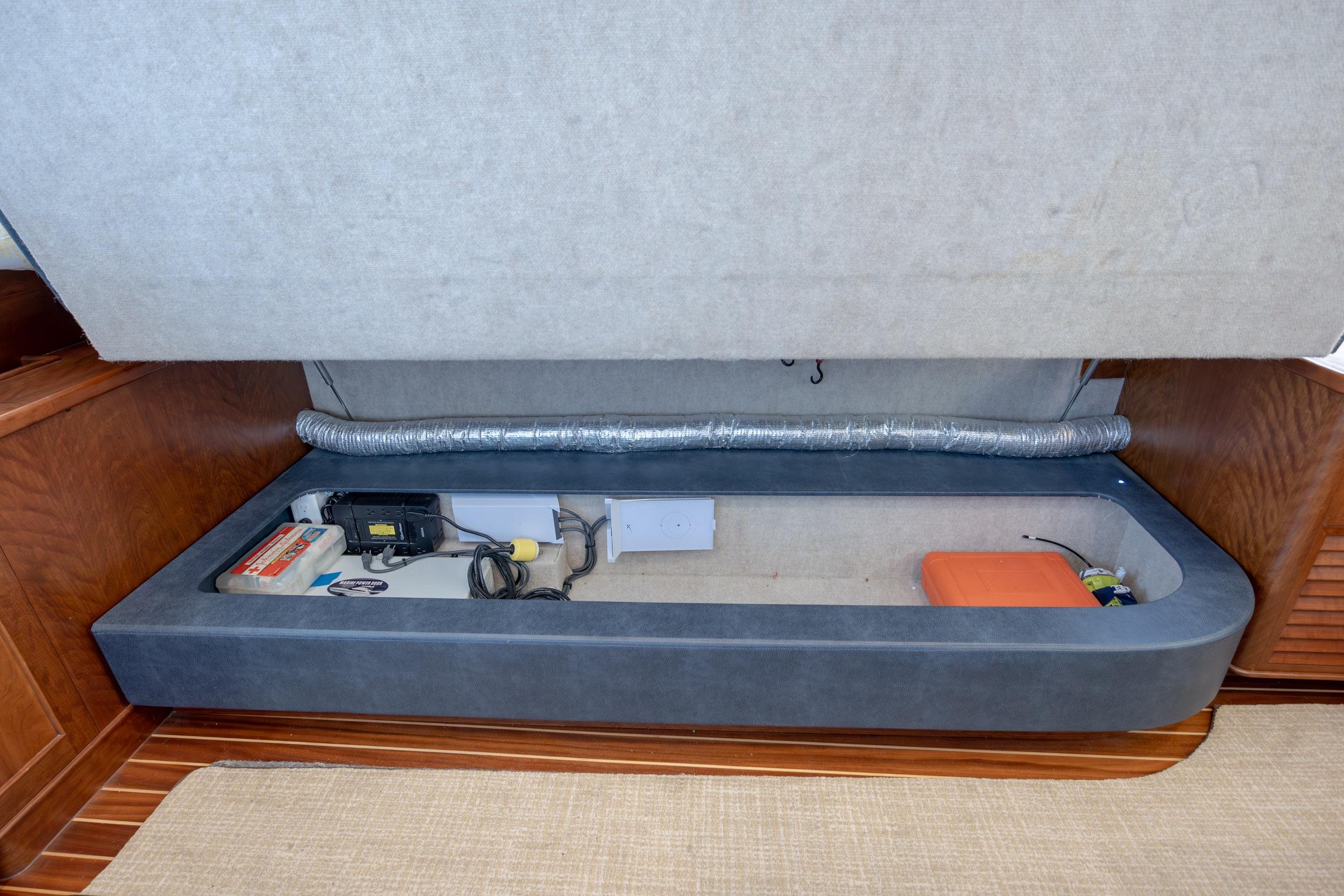 2015 Jarrett Bay Hardtop Express Sportfish interior storage compartment with equipment and wiring.