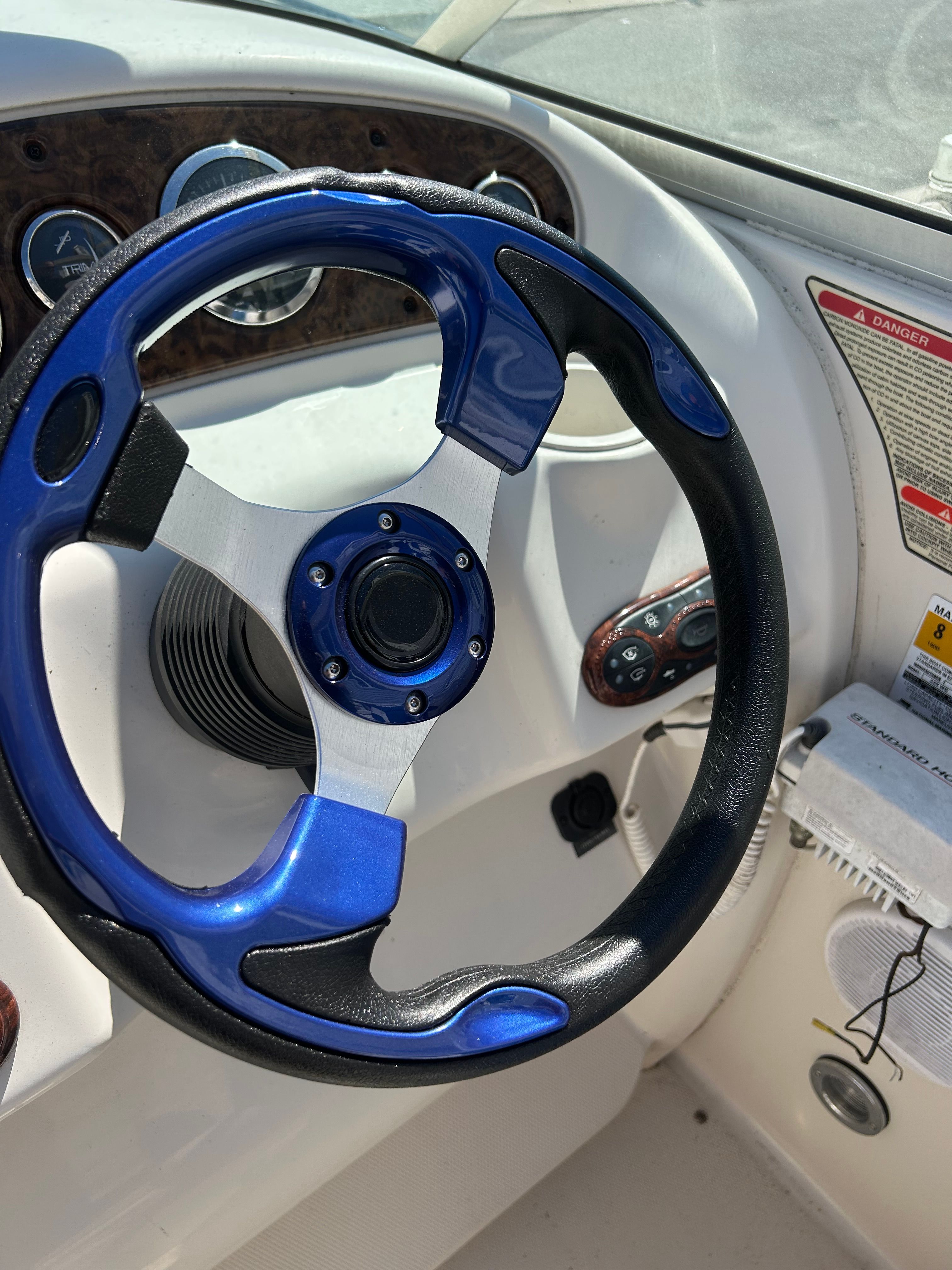 The image shows the helm of a 2002 Sea Ray 225 Weekender with a blue steering wheel.