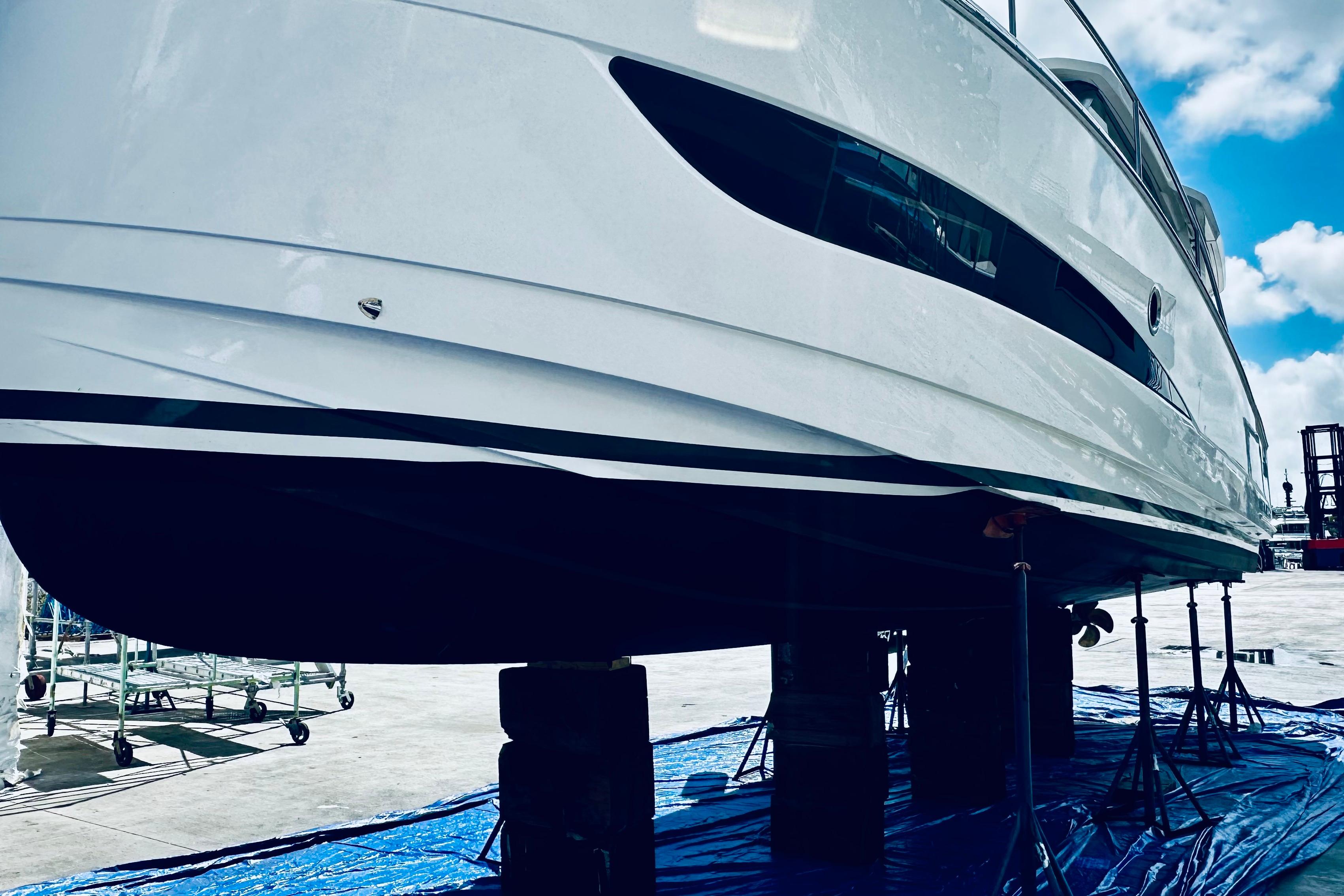 2021 Greenline 39 Hybrid yacht on stands, showcasing sleek design under a blue sky.
