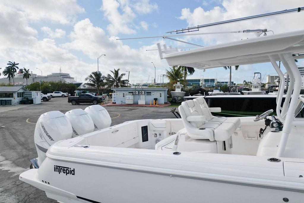 2022 Intrepid 345 Nomad FE boat with twin Mercury engines docked at a marina.