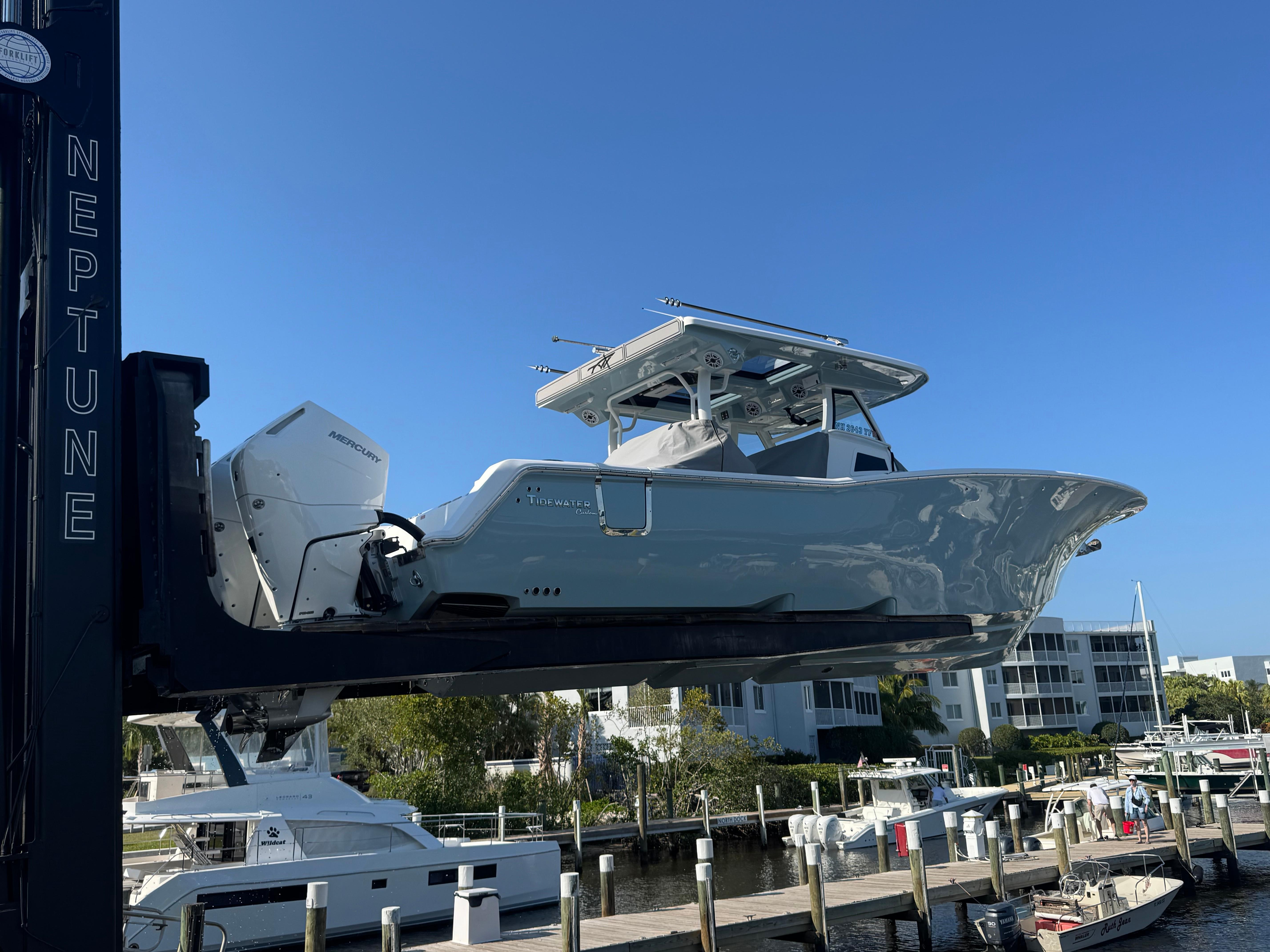 2024 Tidewater 380 CC Adventure boat on lift, dockside view.