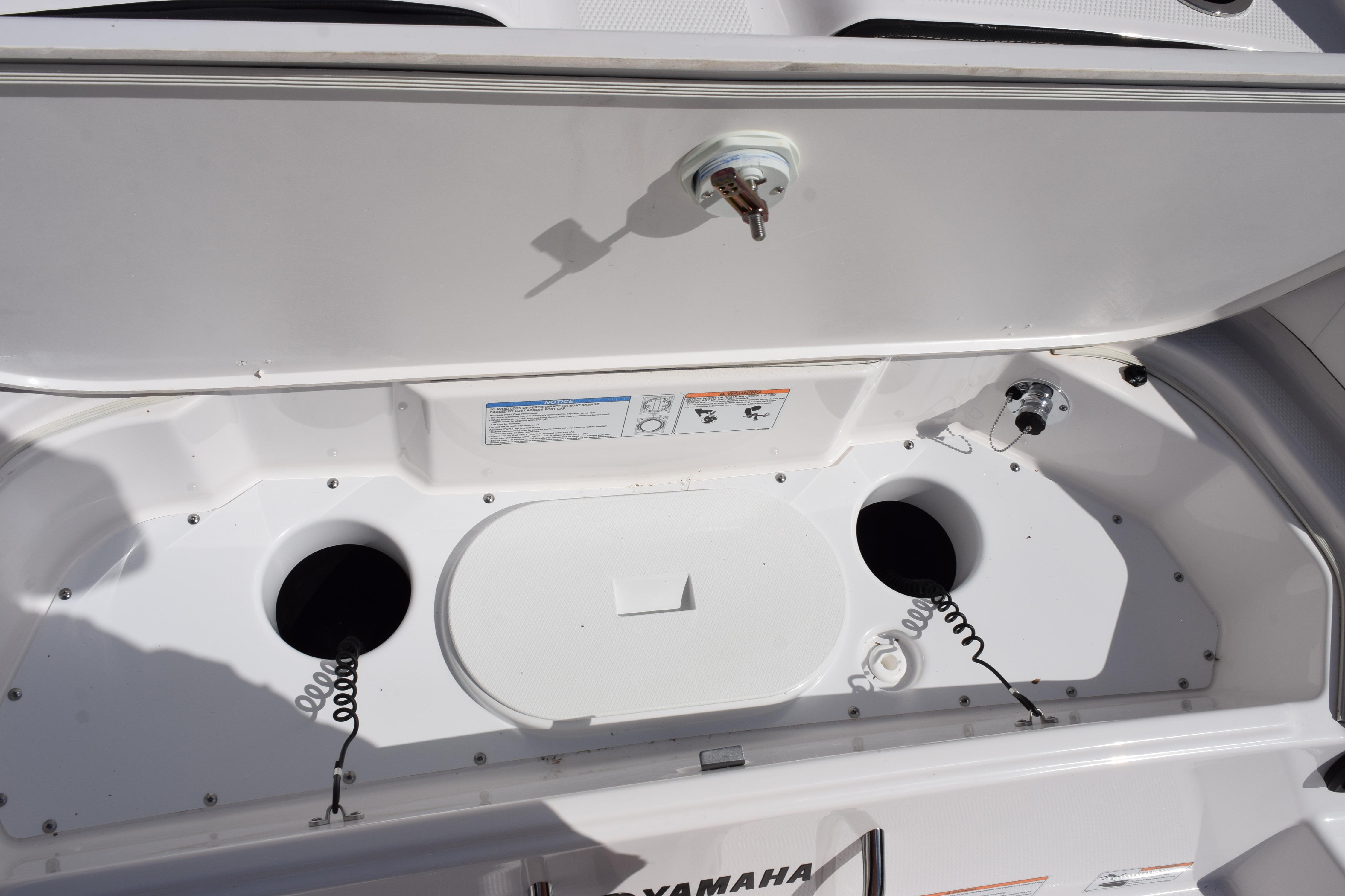 Yamaha Boats 2026 255 FSH Sport H storage compartment with open lid and circular openings.