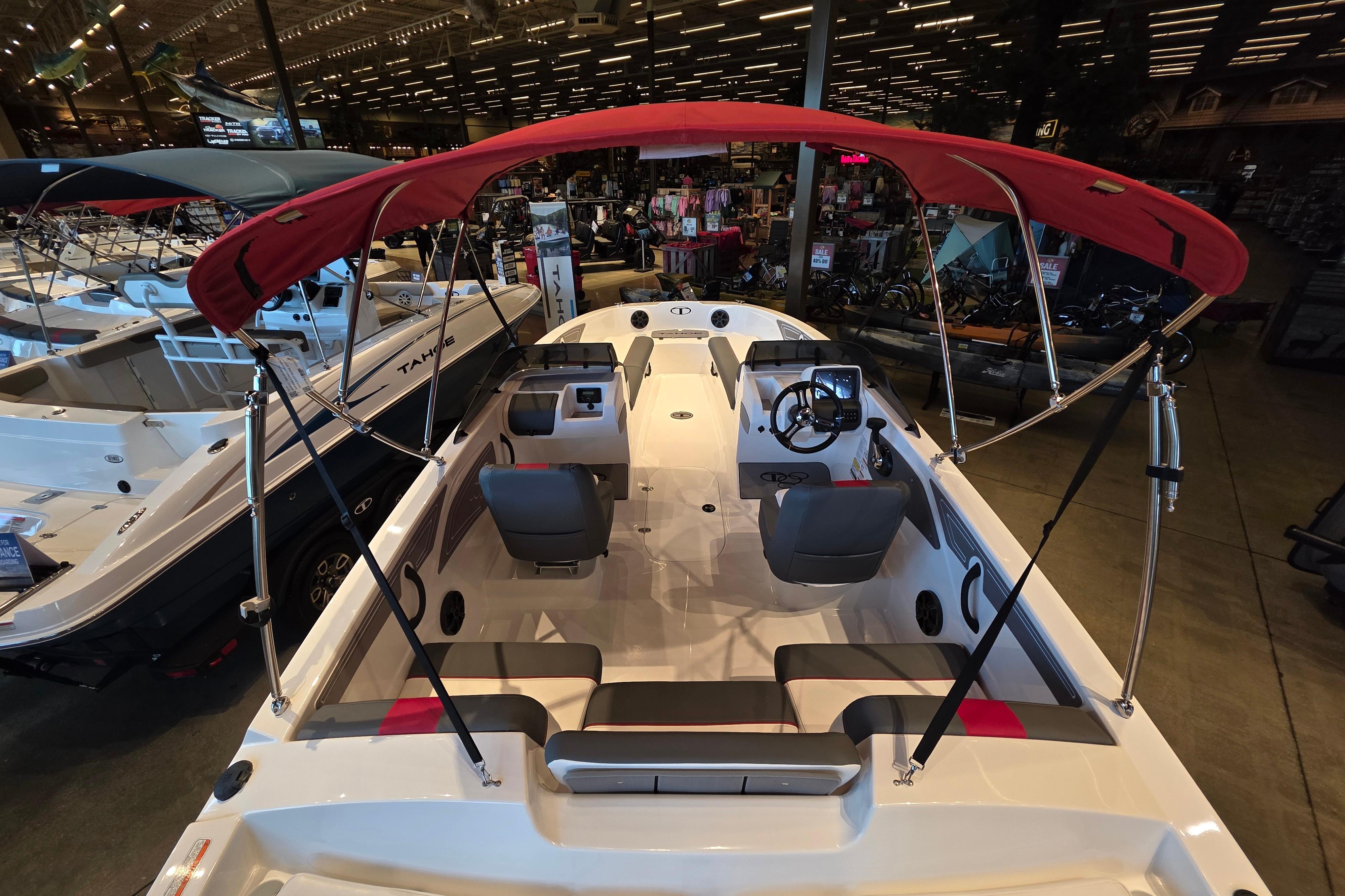 2026 Tahoe T21 boat with red canopy displayed in a showroom.