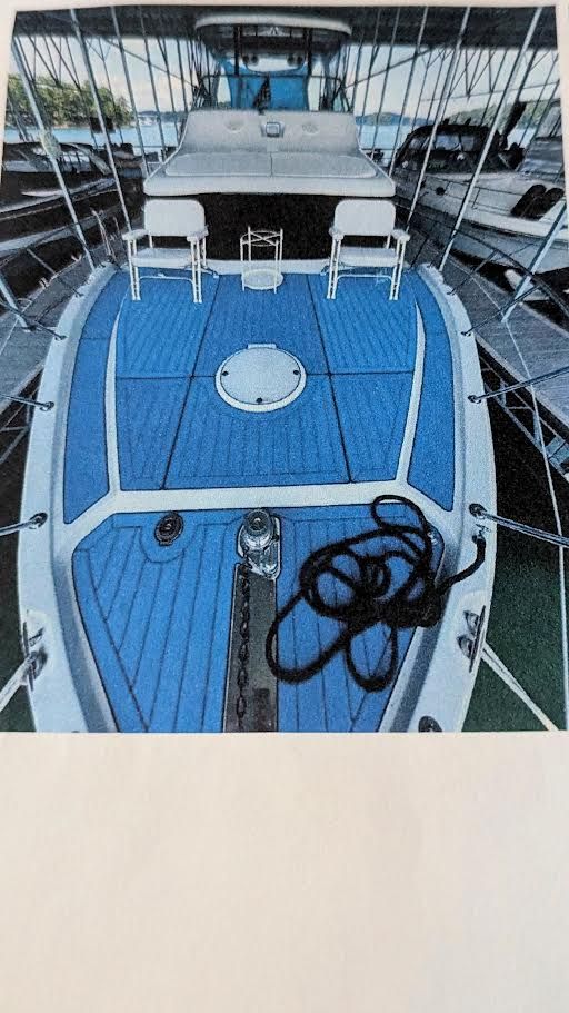 1996 Motor Yacht Blue Water with blue deck in marina.
