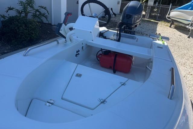 2024 Rigid Boats 10 Sport, white interior, outboard motor, red fuel tank, parked outdoors.