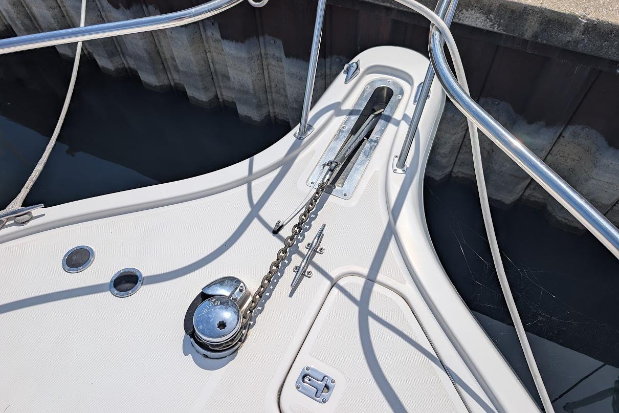Bow of 2000 Pursuit 3400 Express boat with anchor chain and railing.