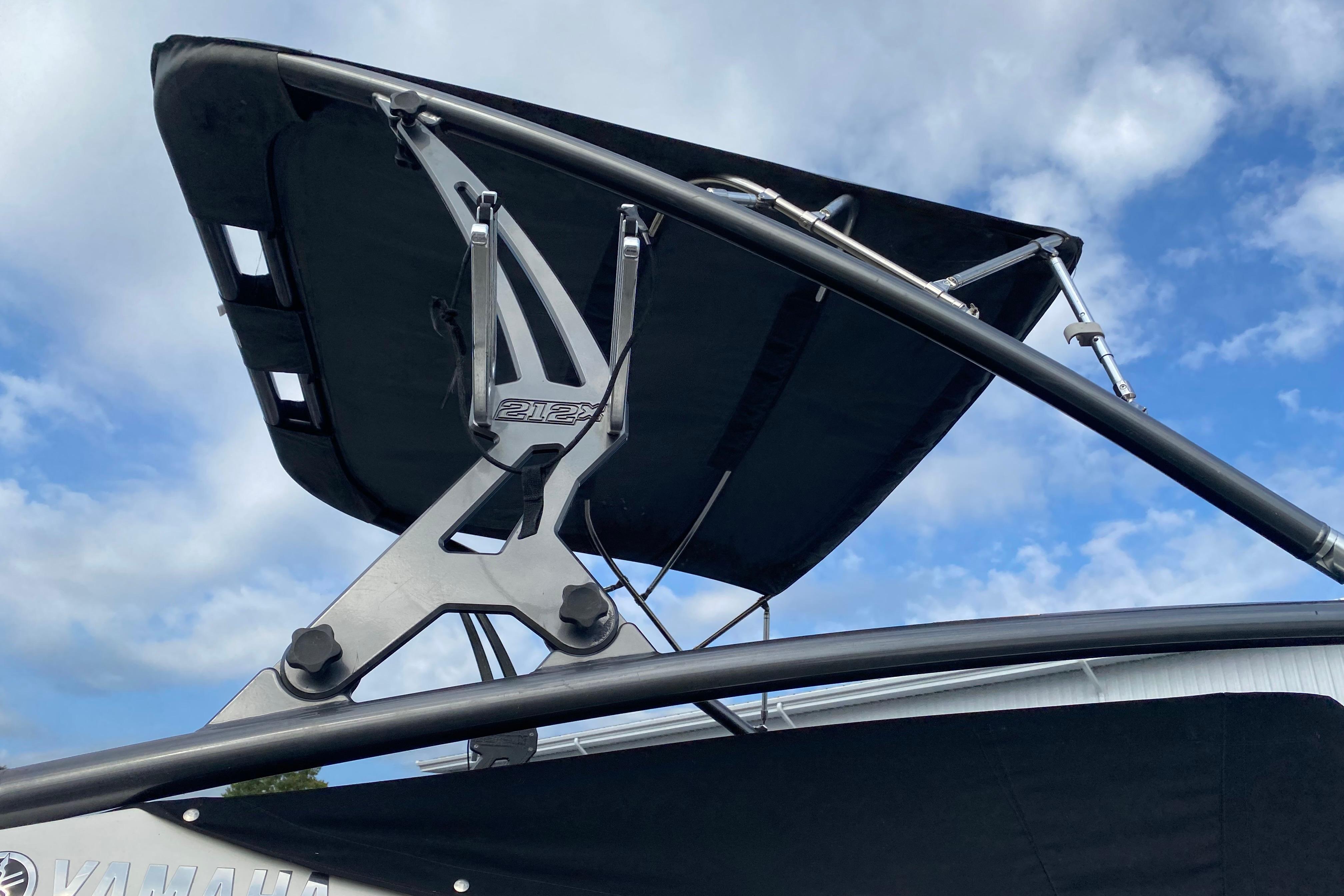 2015 Yamaha Boats 212X wakeboard tower against a blue sky.