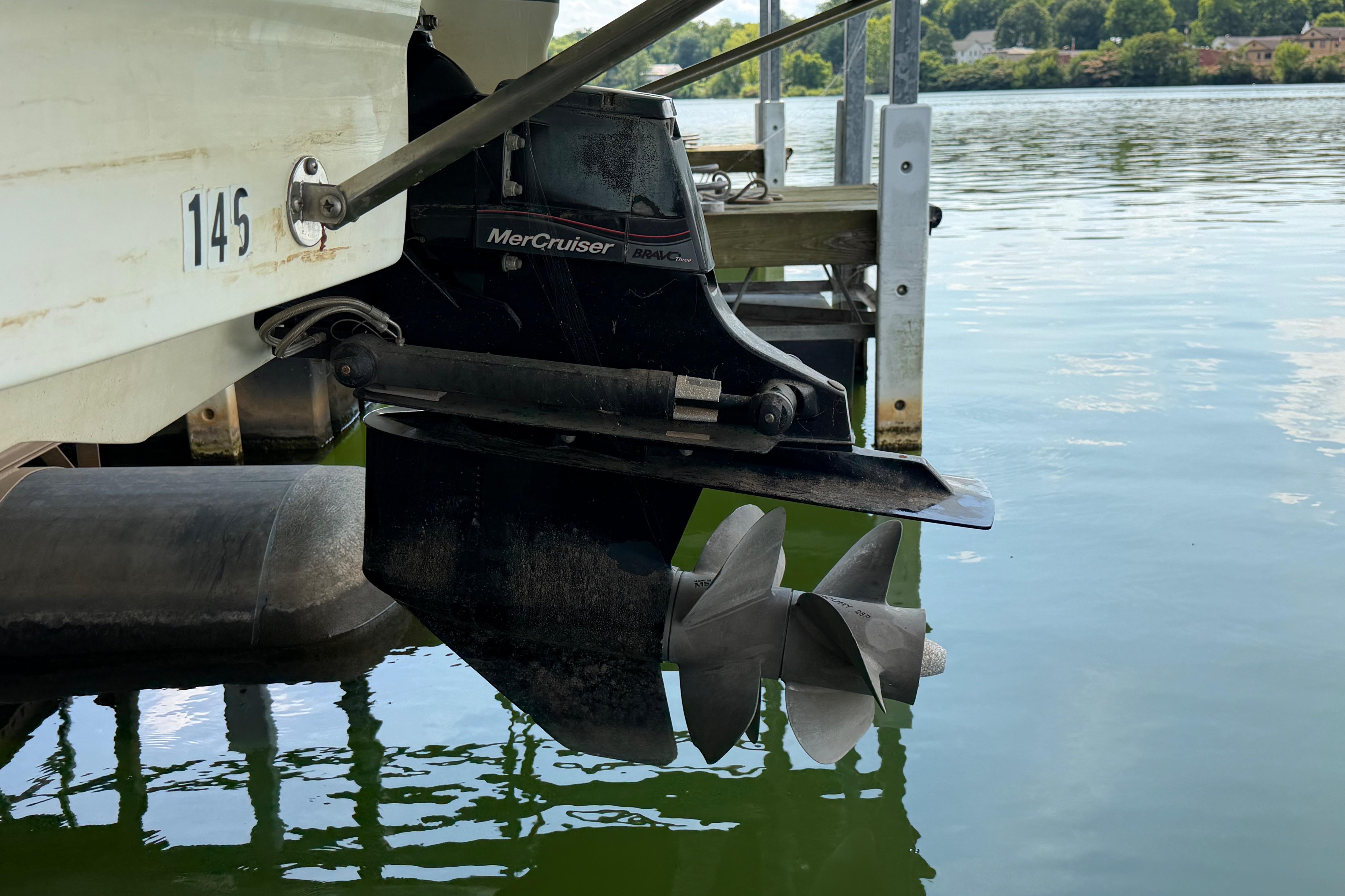 Boat propeller and MerCruiser outdrive on a 2010 Bryant 255 near a dock.
