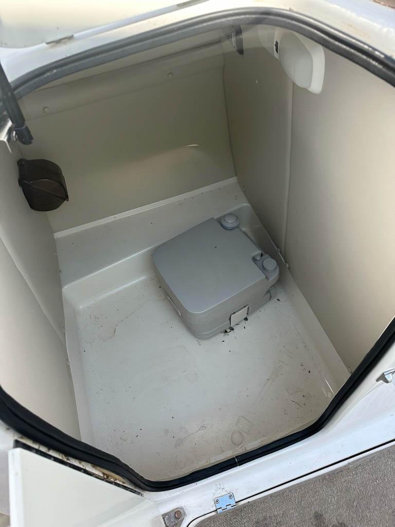 2005 Chaparral Sunesta 252 boat interior storage compartment with portable toilet.