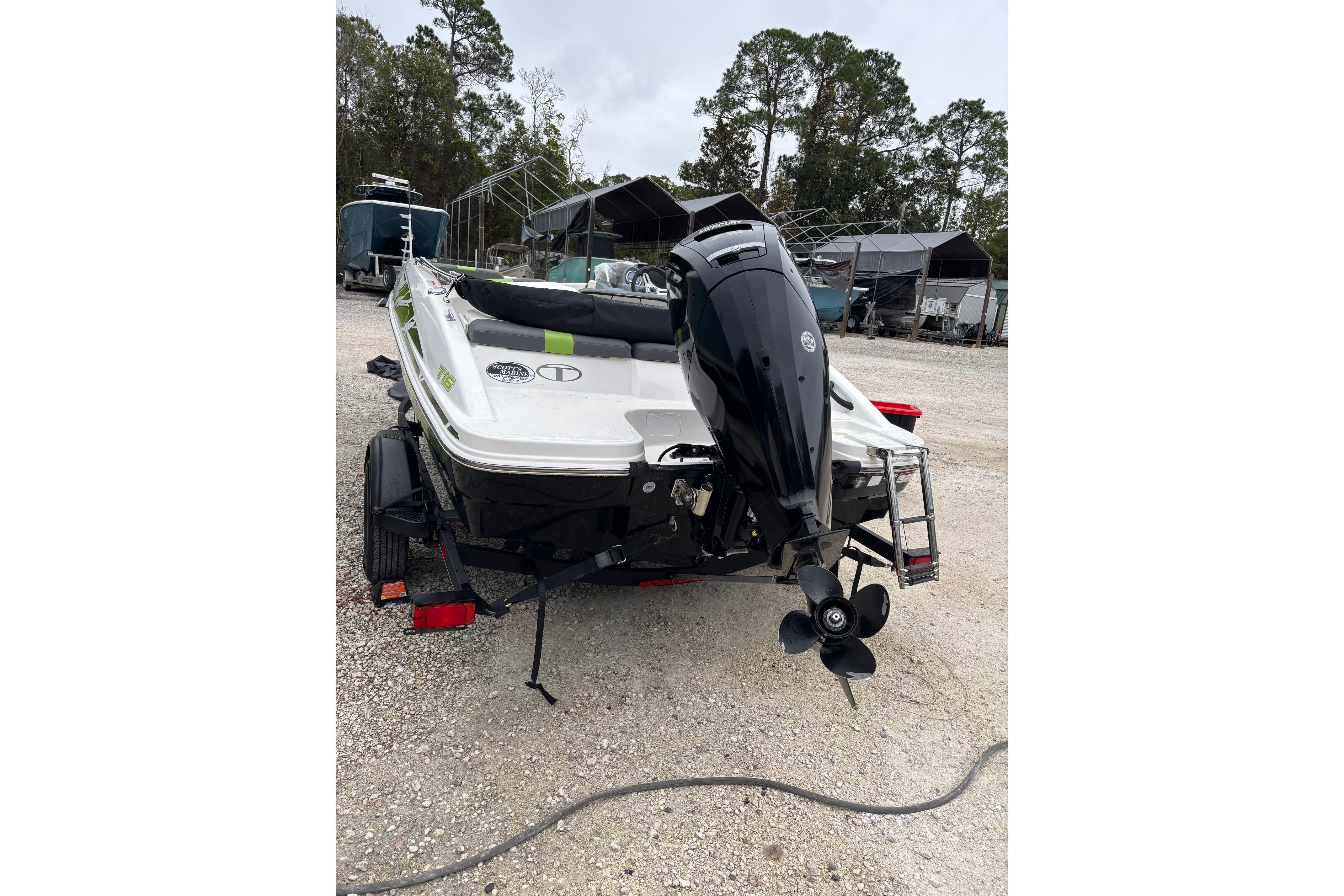 2022 Tahoe T16 boat with outboard motor on trailer, parked outdoors.