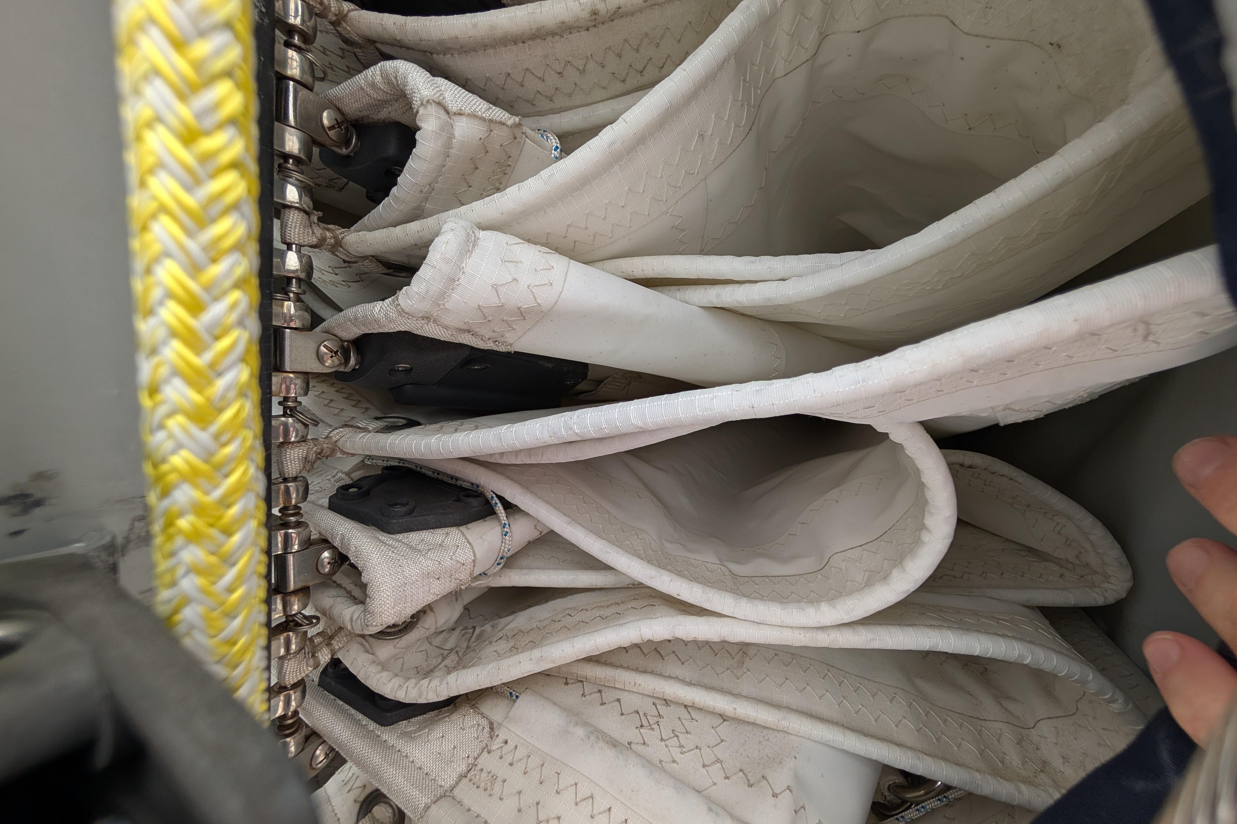 Folded sails on Island Spirit 37 yacht, 1999 model, with yellow braided rope detail.