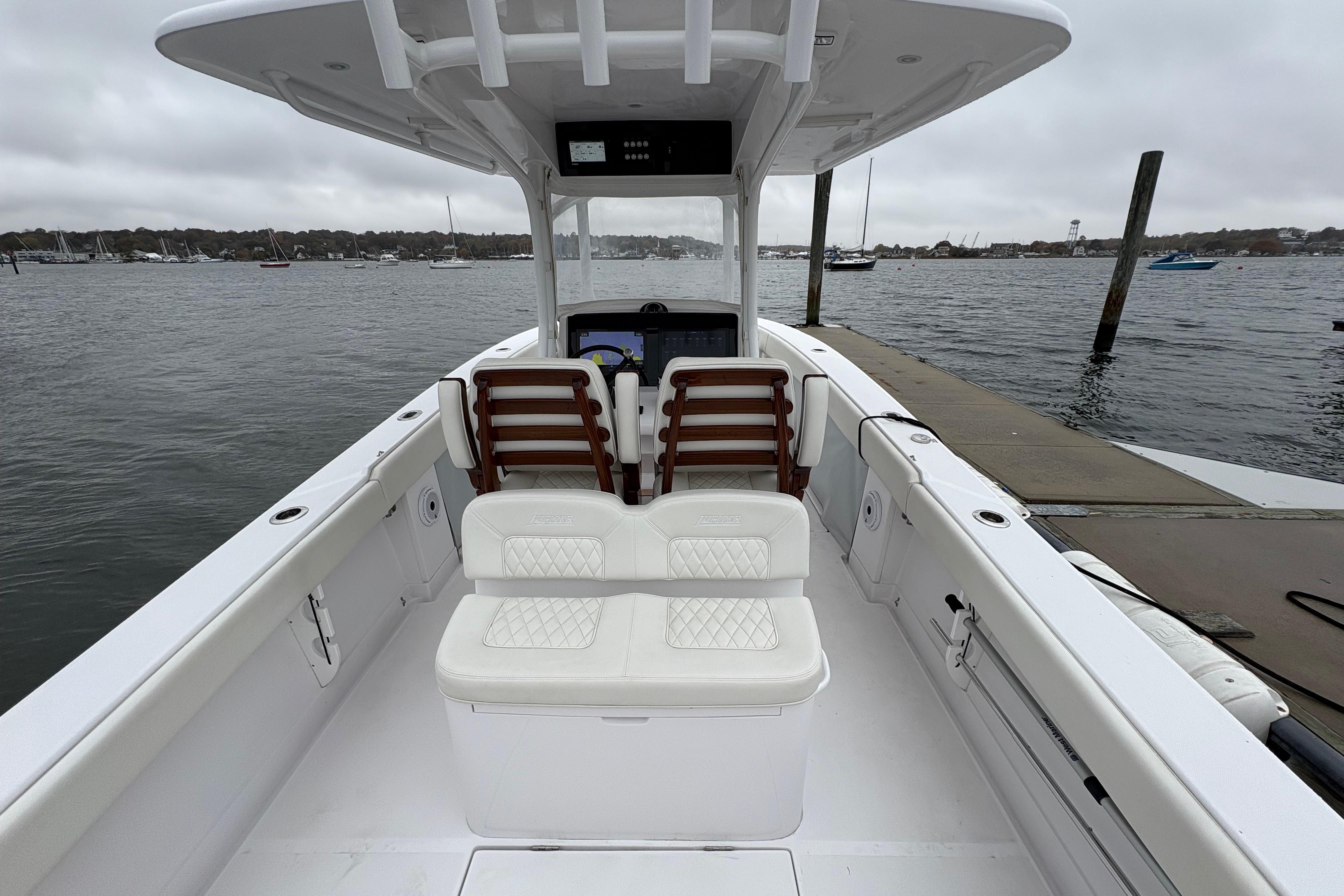 2023 Jupiter 30 boat interior at dock, featuring white seating and open water view.