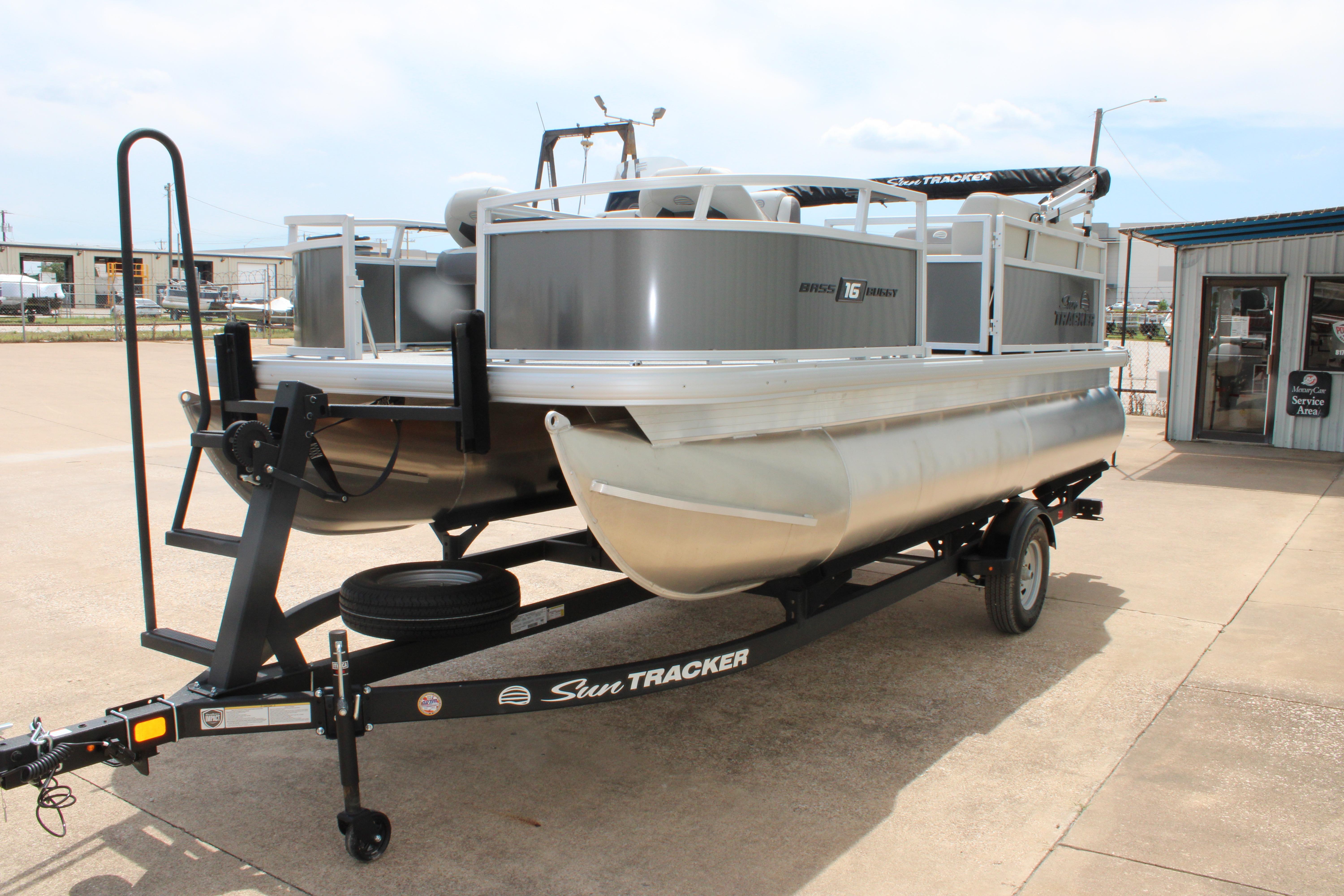 2026 Sun Tracker Bass Buggy 18 DLX pontoon boat on trailer in outdoor setting.