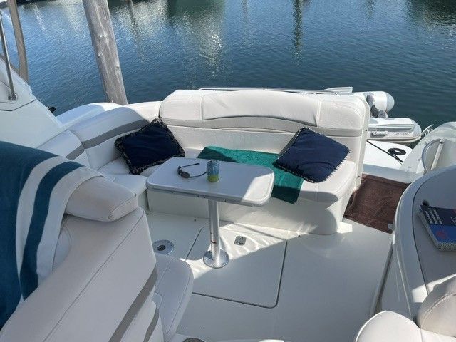 The image shows a boat cockpit with white upholstery and a small table.