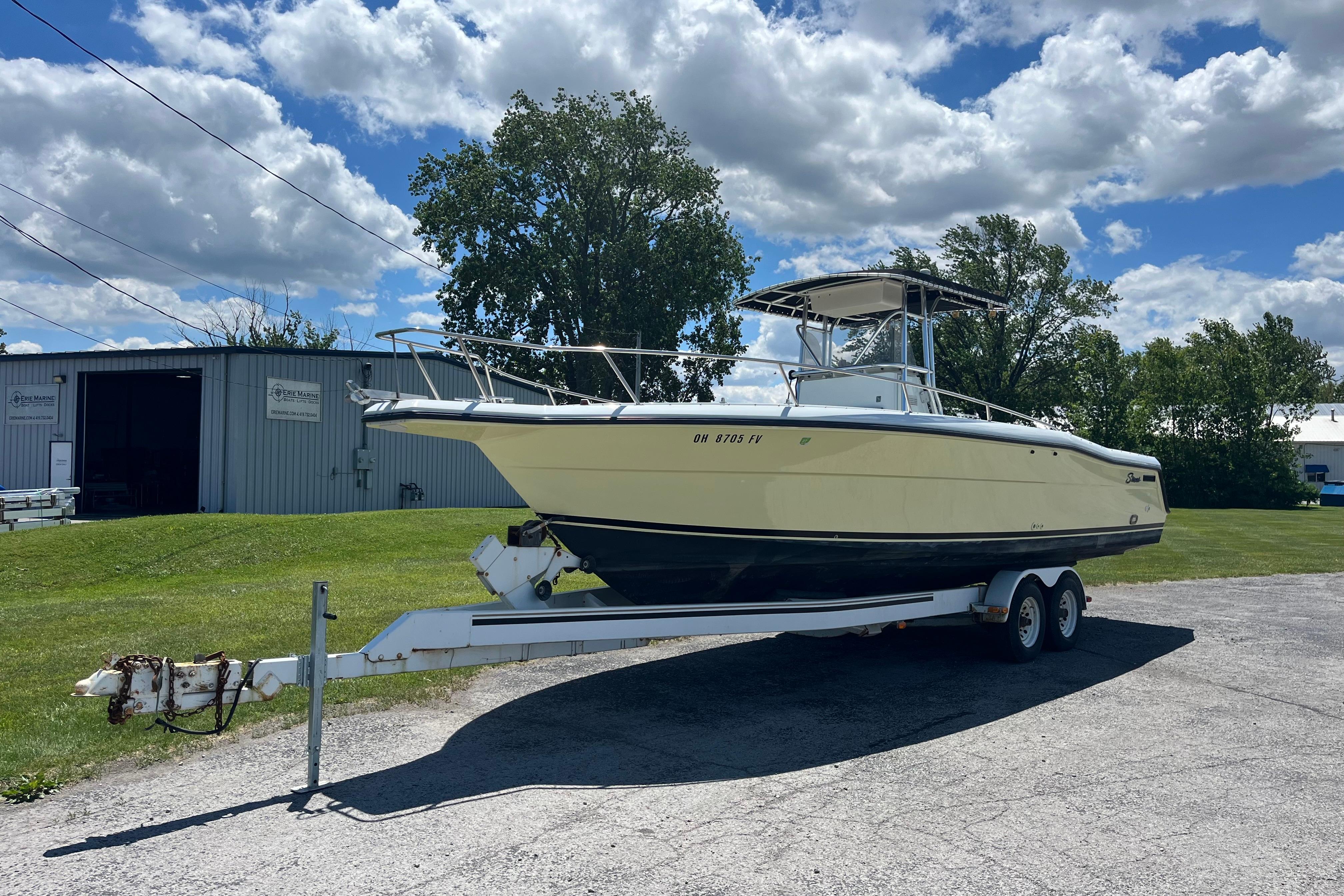 1997 Stamas boat on trailer, parked outdoors under a partly cloudy sky.